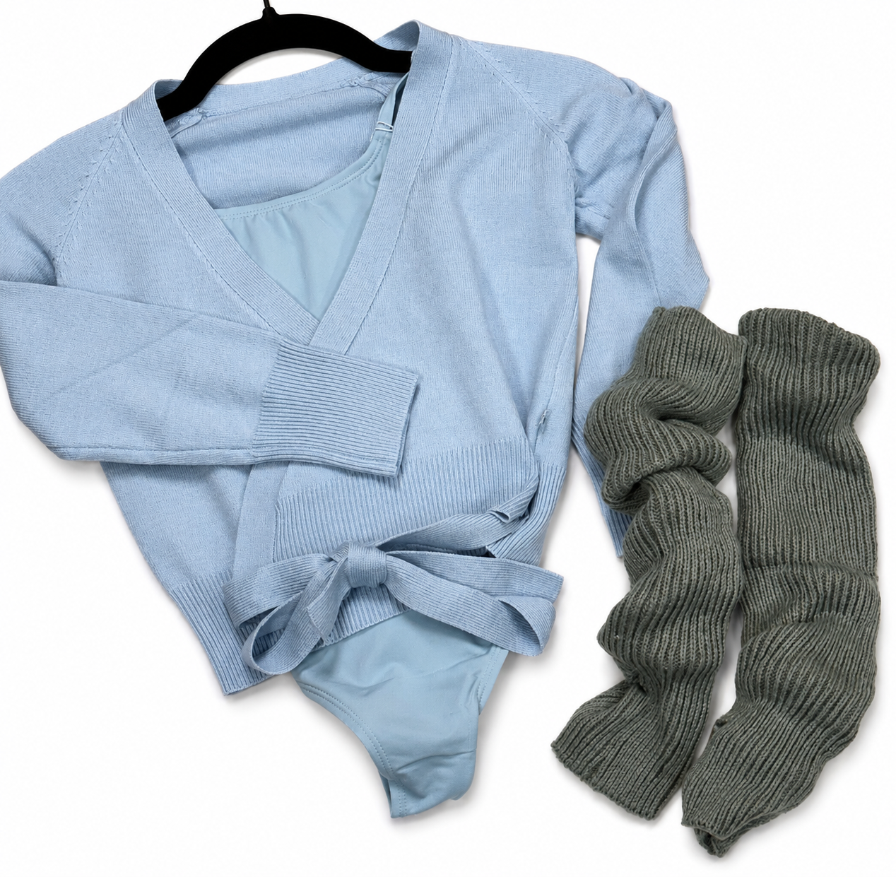 Light blue sweater with a tie at the waist, light blue undergarments, and a pair of dark gray knitted socks laid out on a white background.
