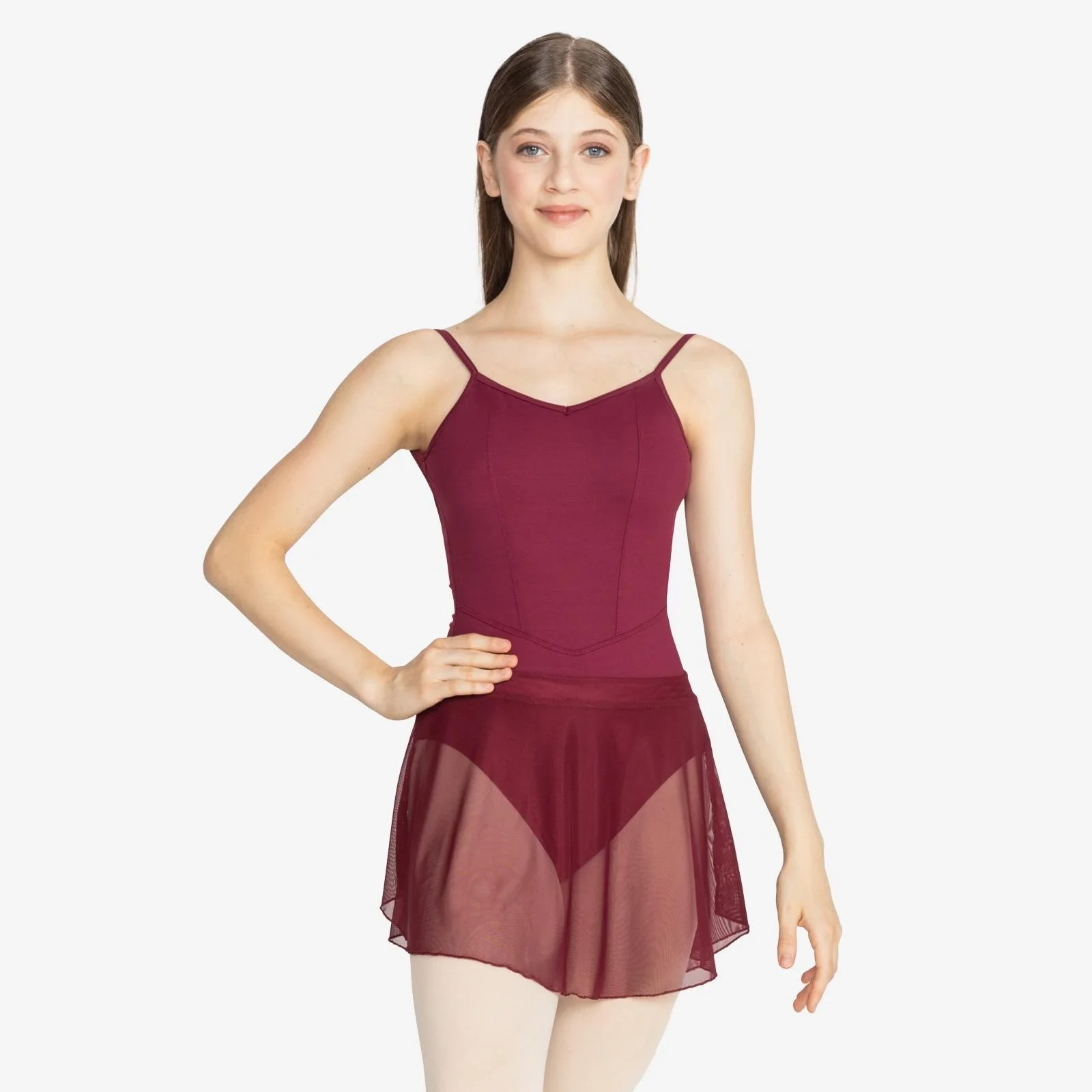 Ballet dancer wearing a maroon leotard with a sheer maroon skirt, standing with one hand on her waist against a plain white background.