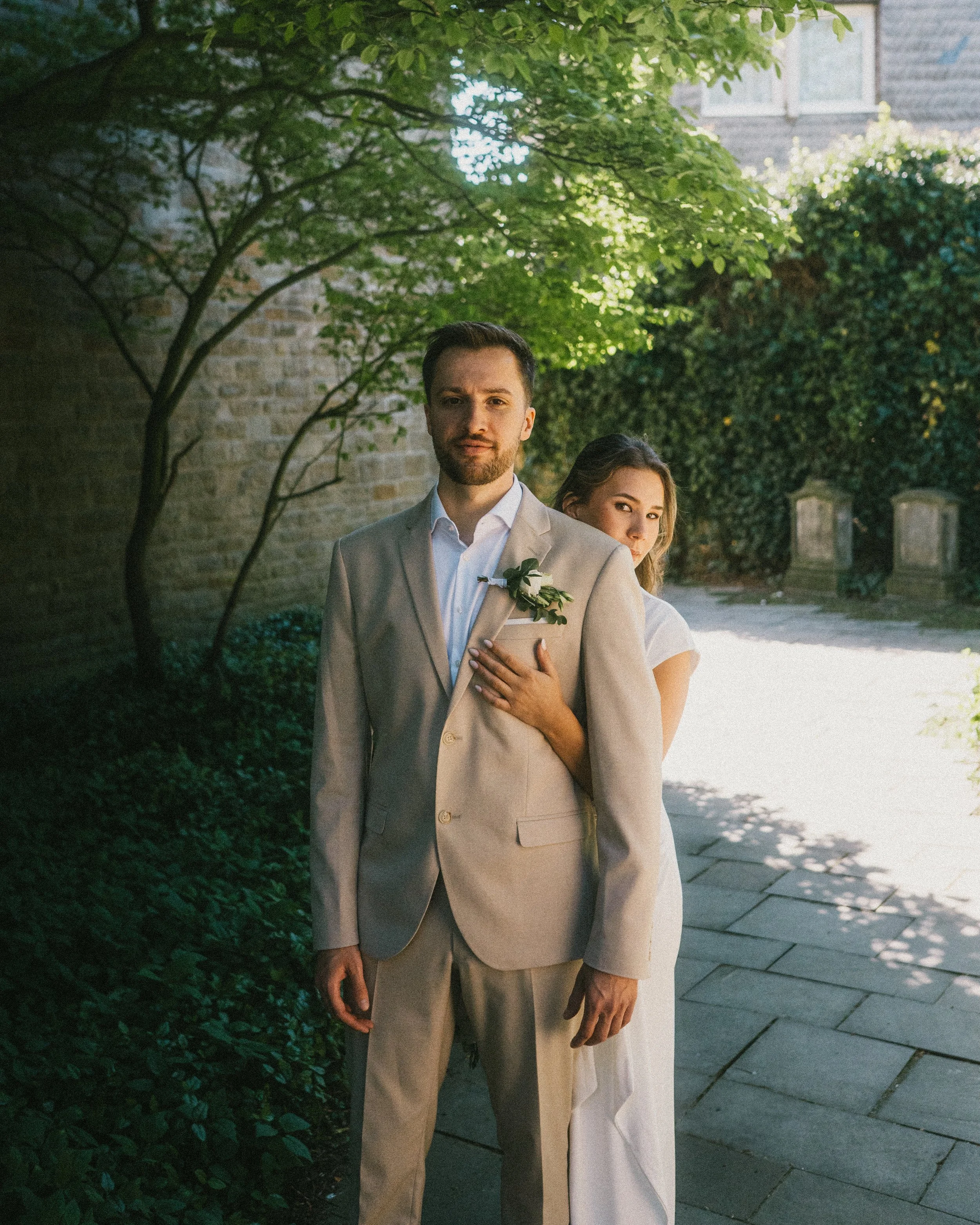 Eine Hochzeitsfotografie  von einem Hochzeitsfotografen von einem Hochzeitspaar hinter dem Standesamt in Herdecke unter einem Baum bei Sonnenschein.