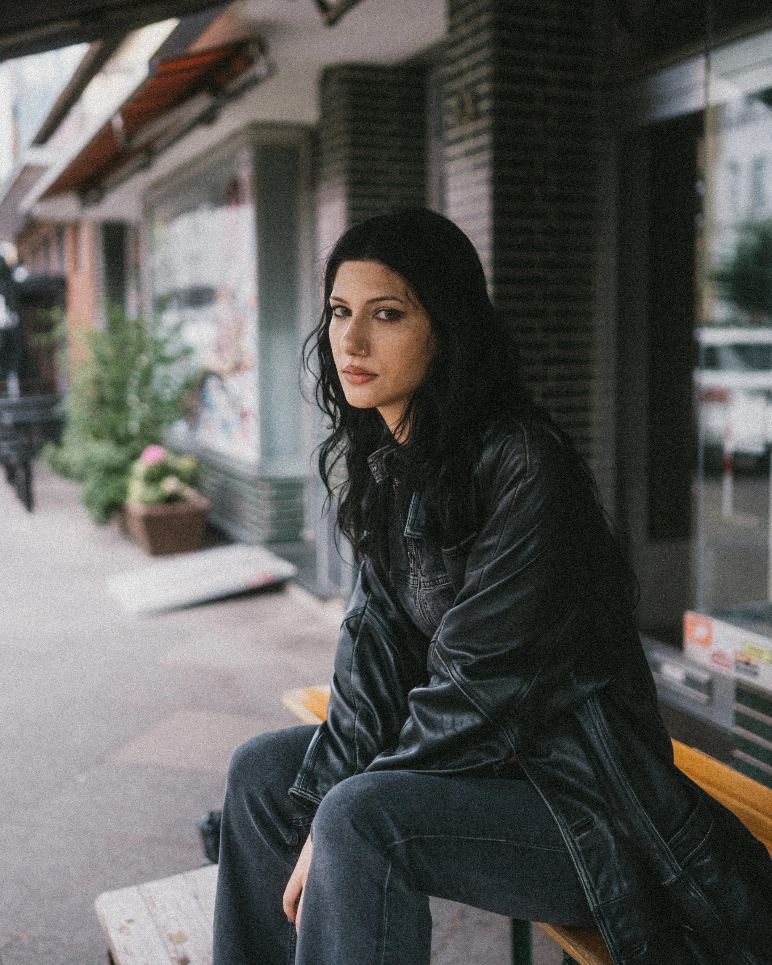Lifestyle-Portrait von einer jungen Frau mit schwarzen Haaren vor einem Café im Kreuzviertel in Dortmund.