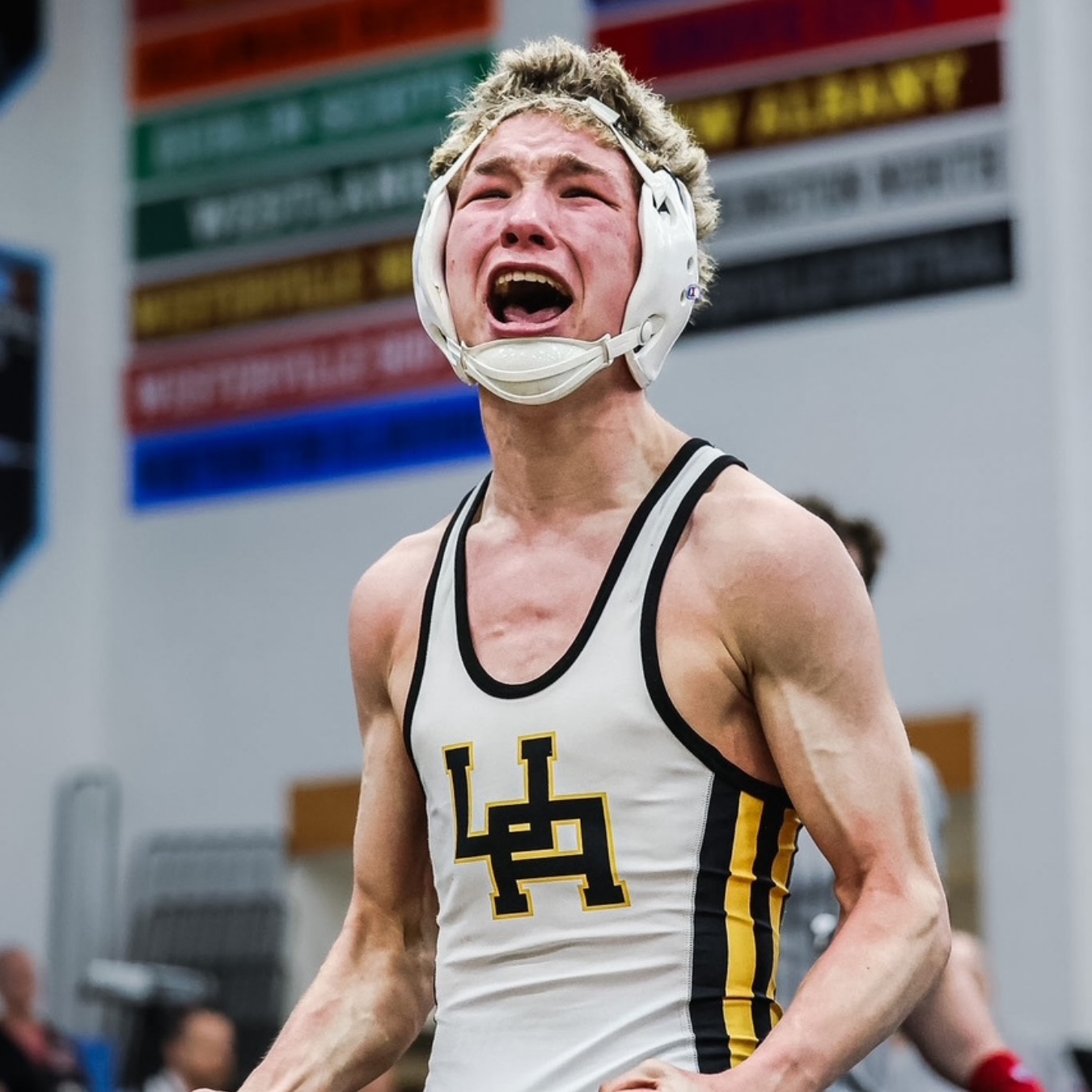Image of a wrestler with his mouth opening flexing his muscles
