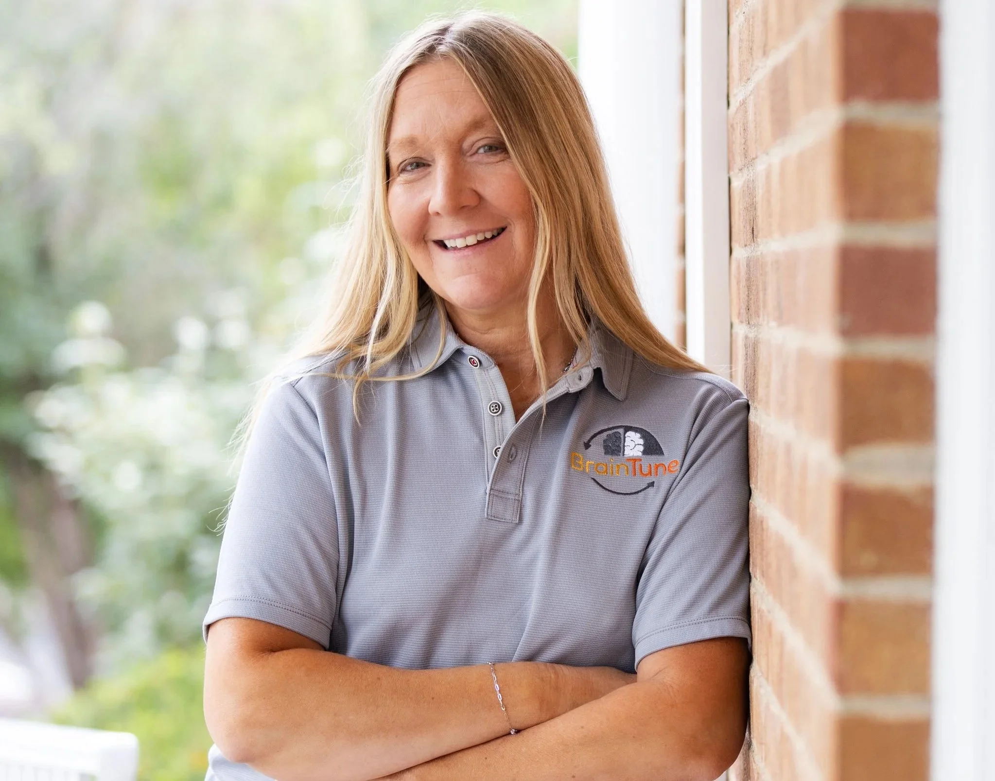 headshot of Brain Tune team member with gray Brain Tune shirt and blond hair