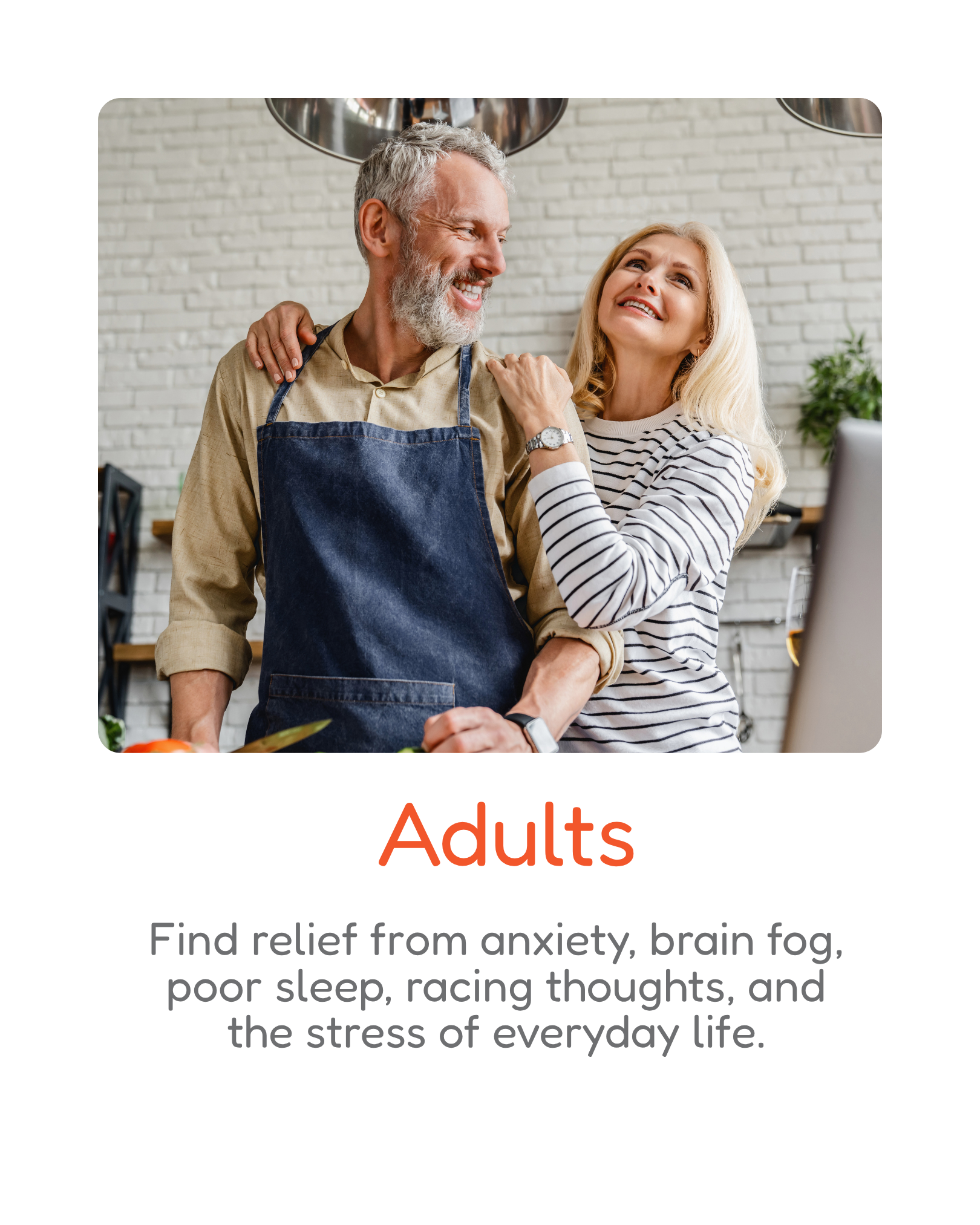 A smiling older man with white hair and a beard wearing an apron, standing next to a woman with long blonde hair, both smiling in a bright kitchen with a white brick wall, a plant, and a computer. The word "Adults" is written below in orange.