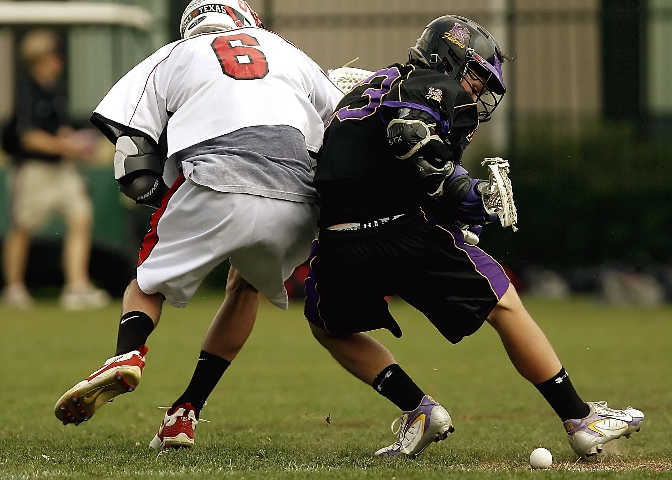 Image of two lacrosse players playing lacrosse bumping into each other
