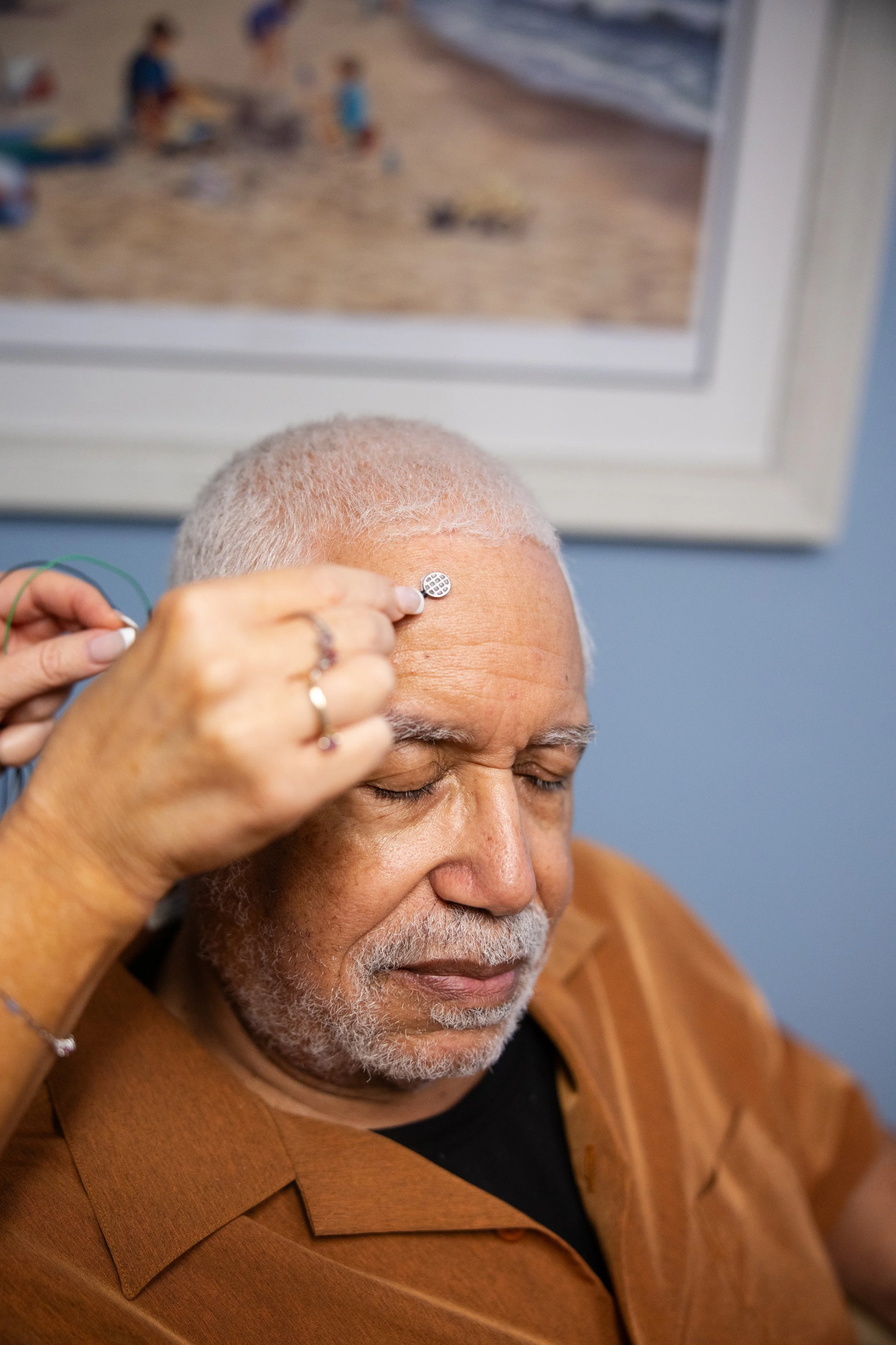 Image of older man with brain micro on his forehead with his eyes closed