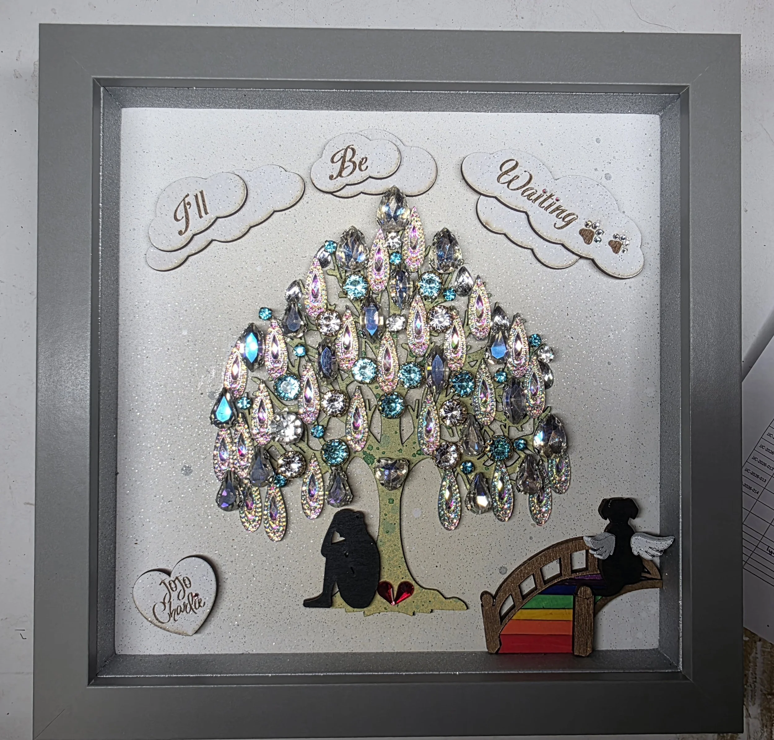 A decorative display with a rhinestone-embellished crown and various tags, including one with the phrase 'I'll Be Waiting...'.