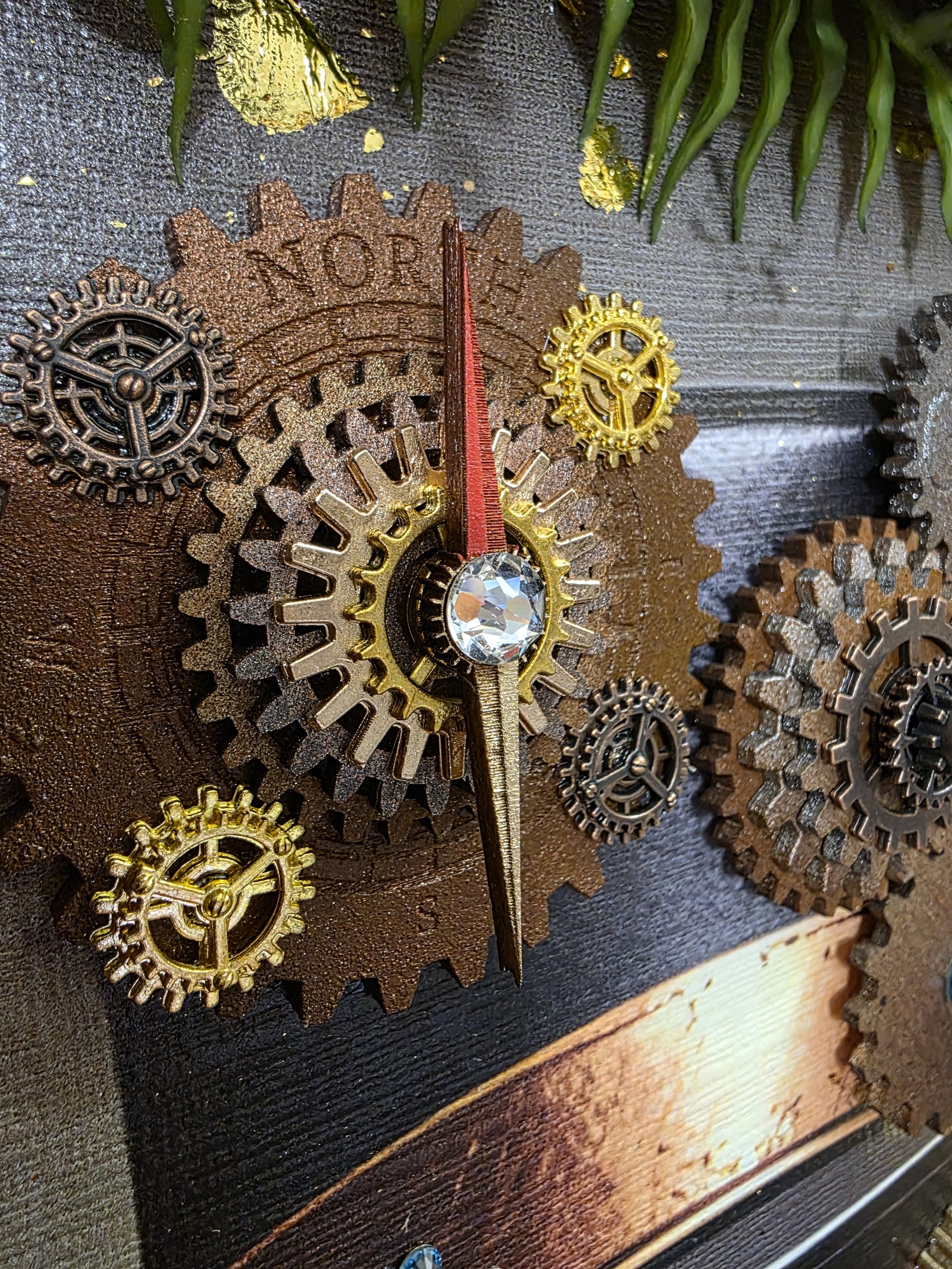 Close-up of a vintage clock with gears and a sparkling jewel in the center, mounted on a textured wooden surface.