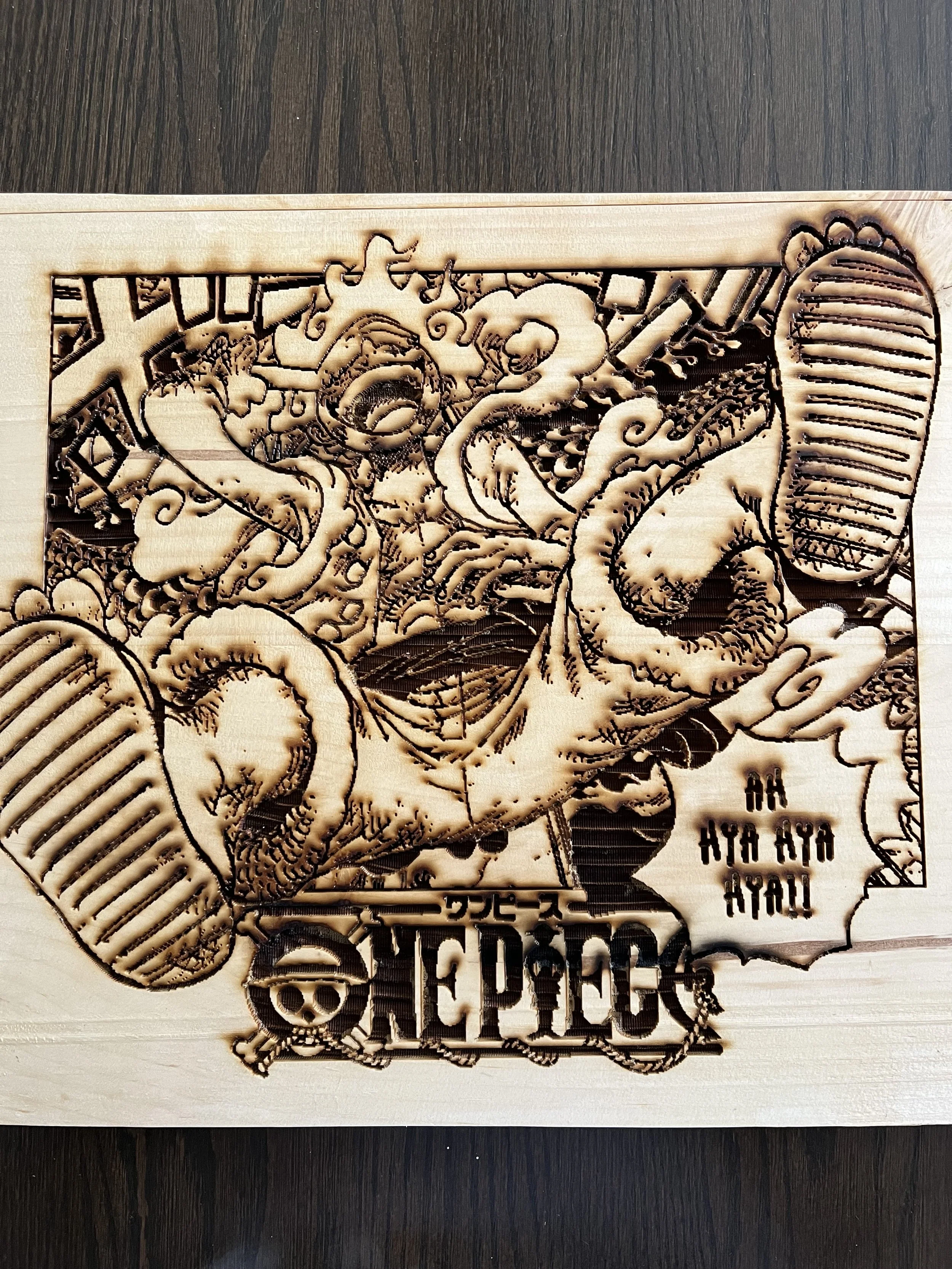 A wooden cutout featuring a detailed tattoo-style design of a mermaid with long flowing hair, holding a fish, and surrounded by various elements such as a skull, flowers, and banners with text. The design is carved into the wood, creating a relief pa