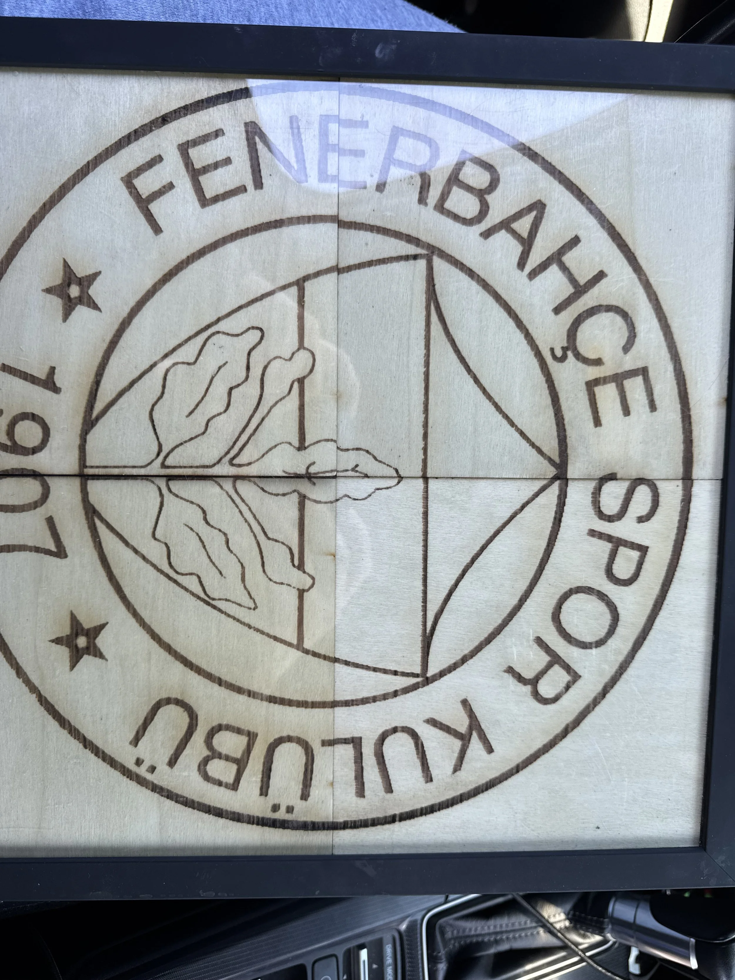 The image shows a circular logo with the text 'FEE NERBACH' and 'OF' within the circle, along with some graphic elements such as stars and a mountain scene.