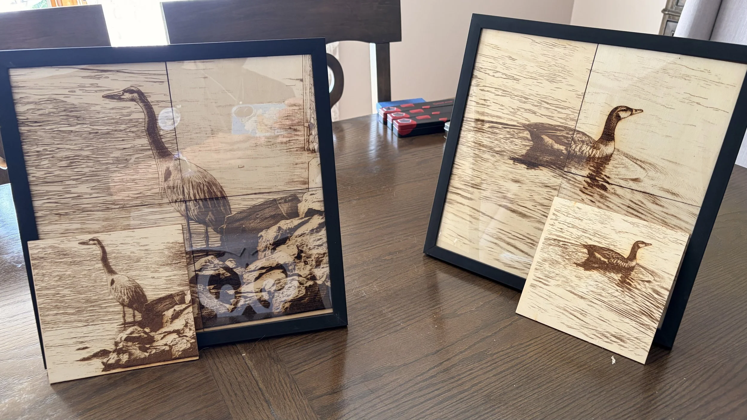 Four framed pictures of a goose standing in water, displayed on a table.
