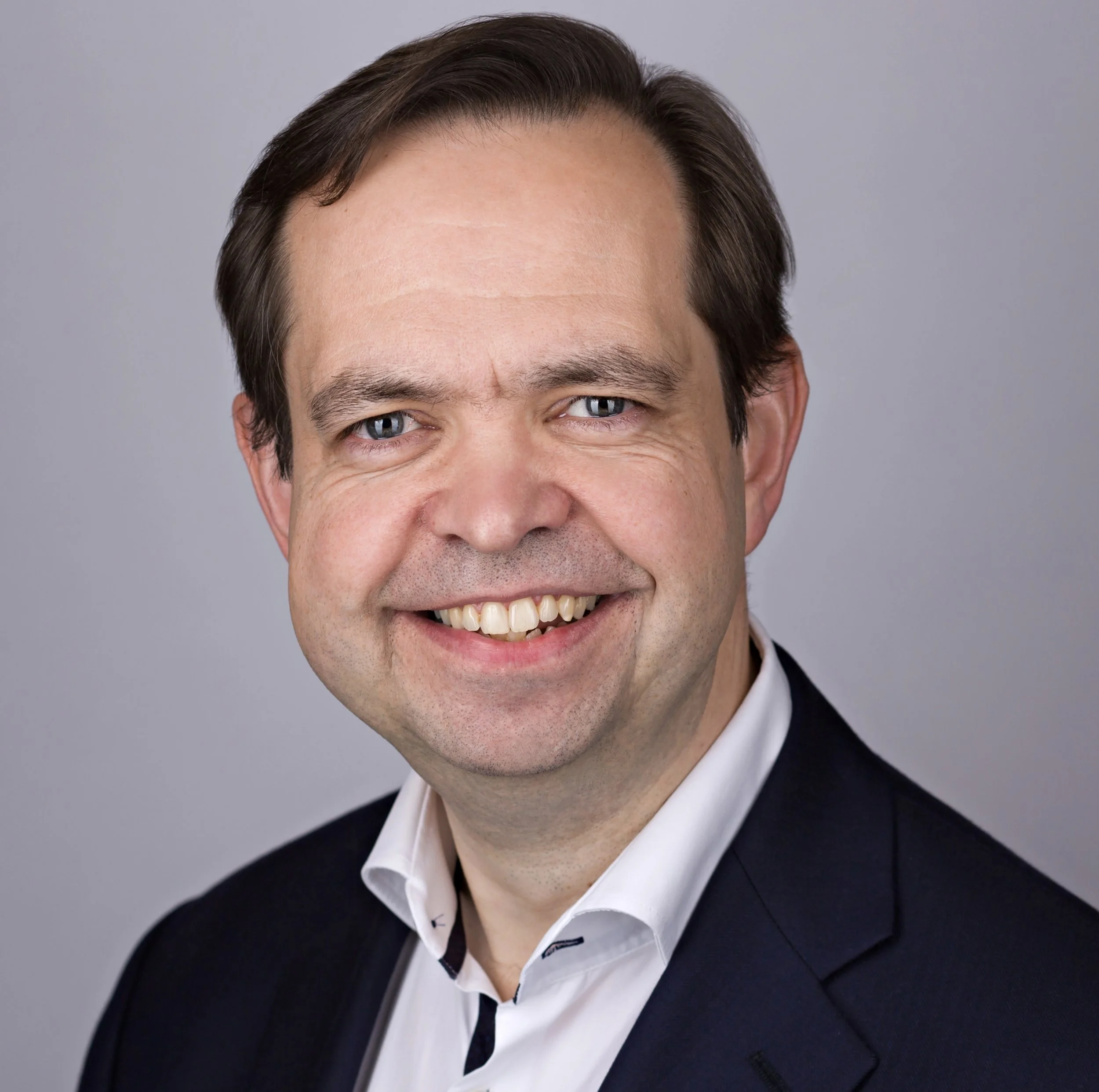Gerry Lawrence wearing a white dress shirt and a black blazer.