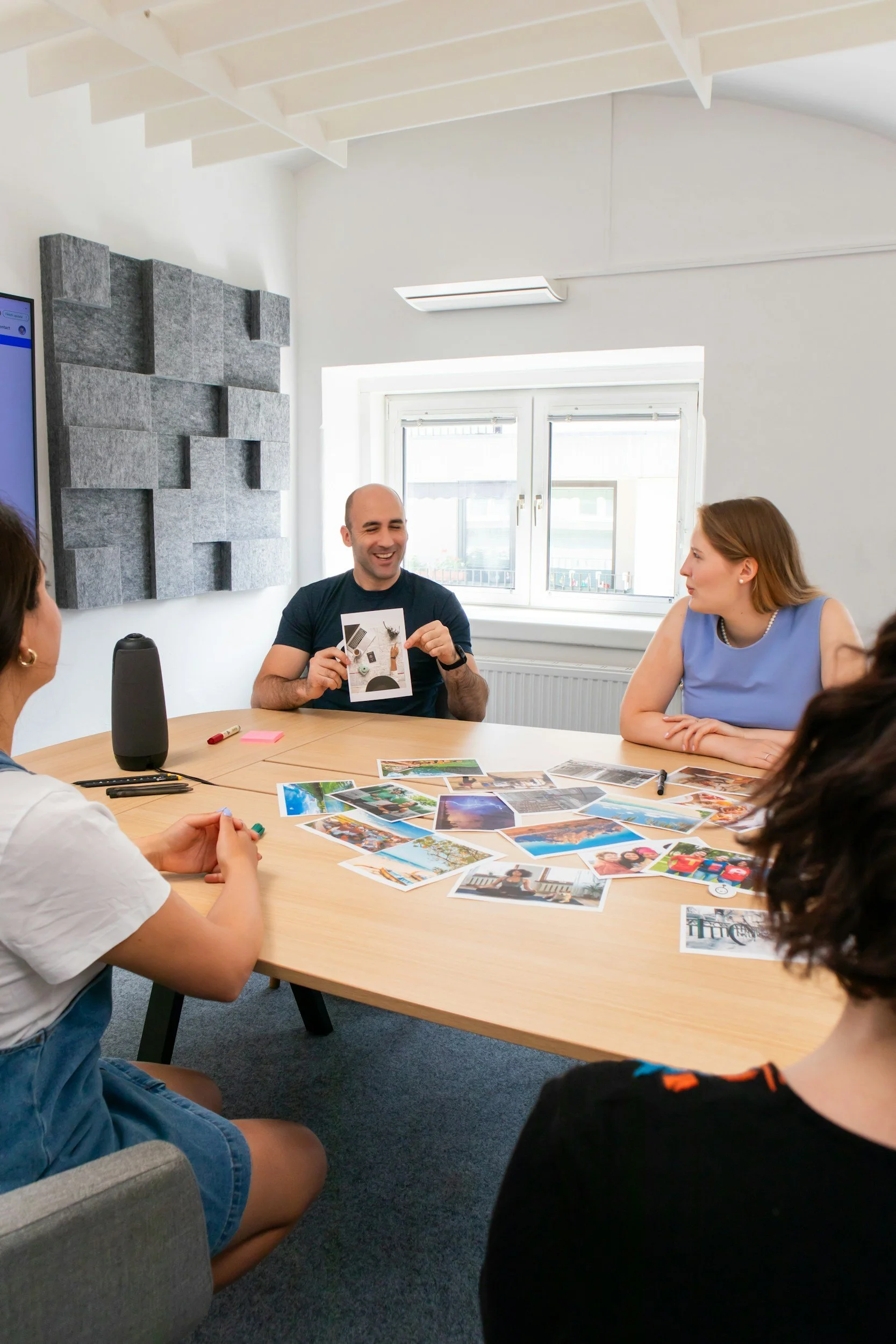 Two people in a meeting reviewing documents and photographs spread across a table