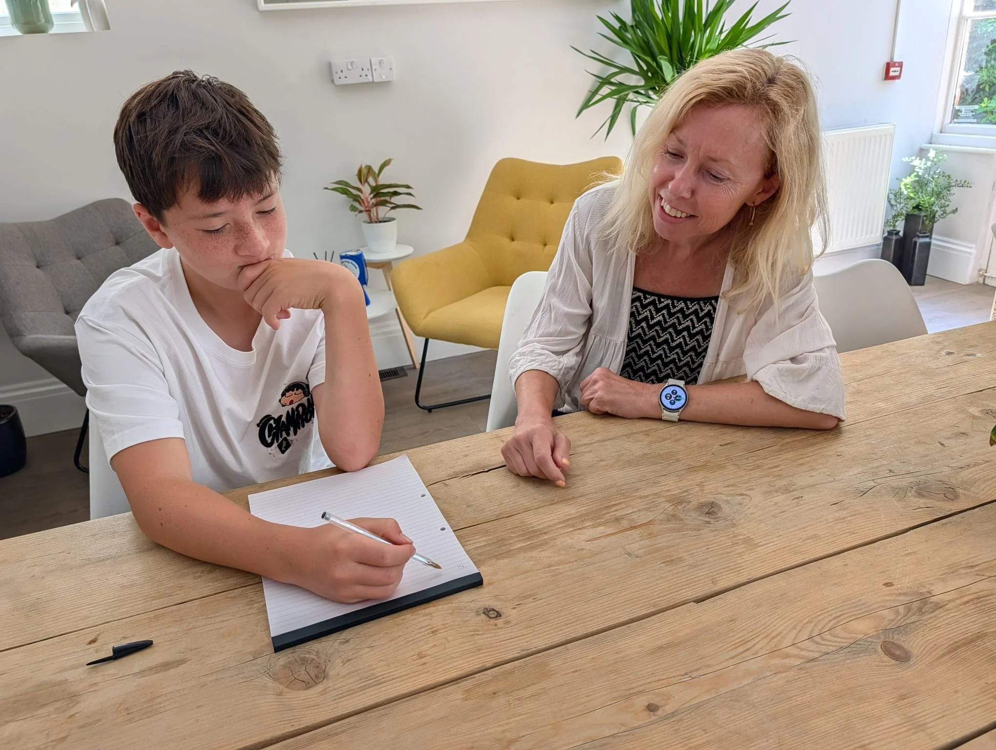 Rachel Martin sitting at a table with a young student during a one-to-one tutoring session