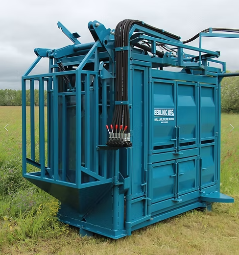 Blue hydraulic fracturing tool in a grassy field with overcast sky.