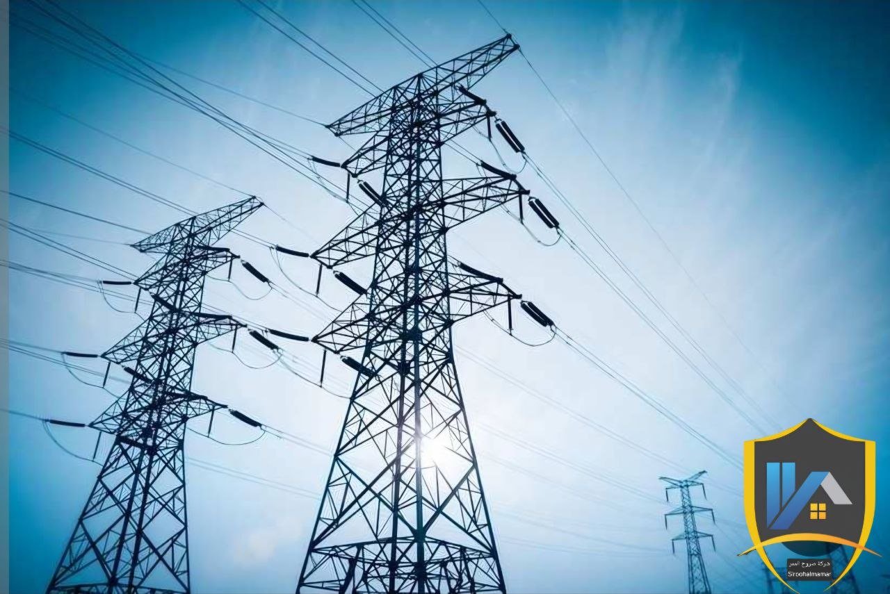 Multiple electrical transmission towers with power lines against a bright sky.