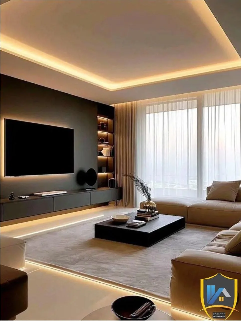 Modern living room with a large window, beige sofas, a black coffee table, a flat-screen TV on a dark wall, and built-in shelves with lighting, illuminated by recessed ceiling lighting.