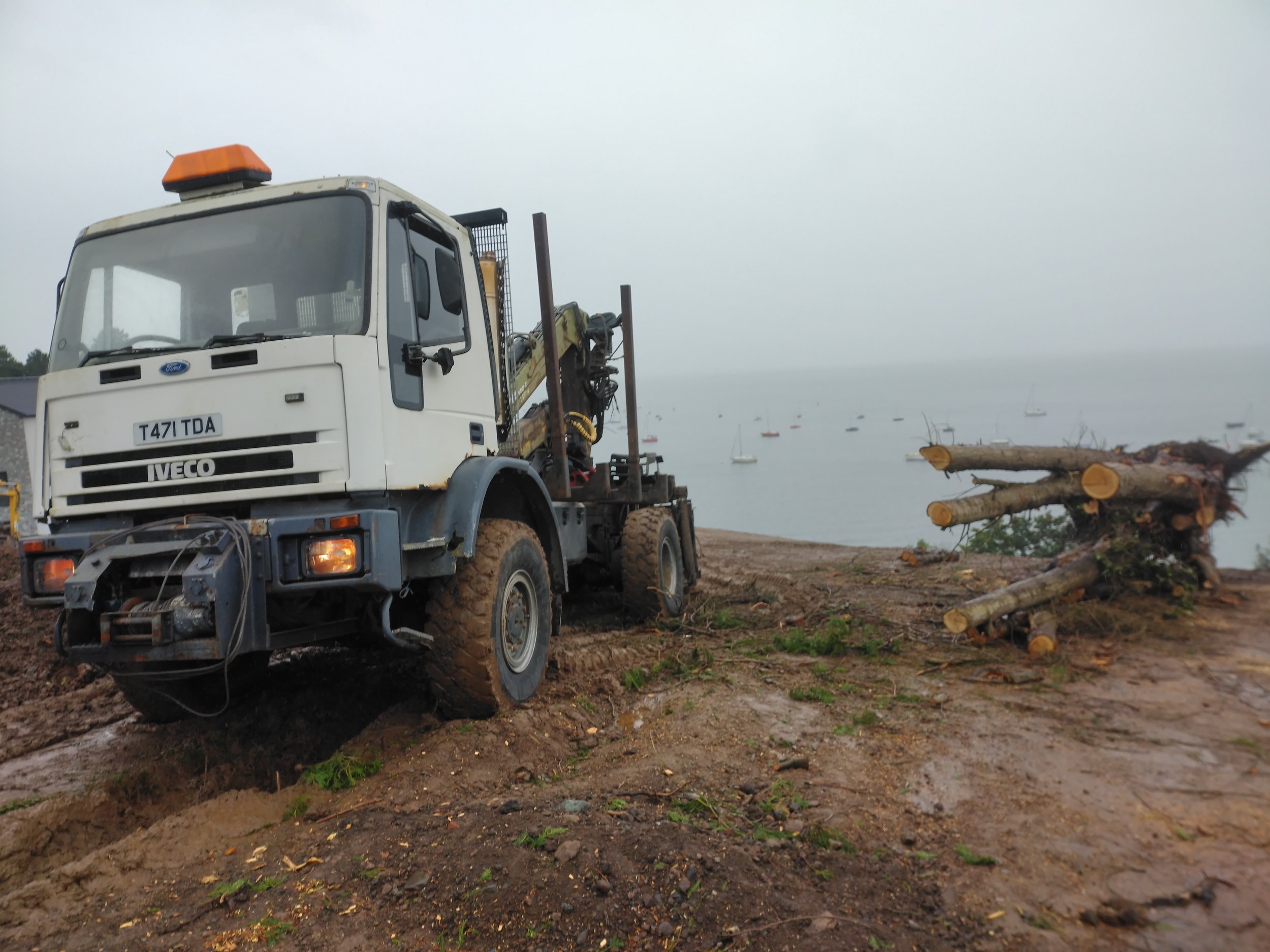 Iveco 4x4 radio remote crane truck with grapple for mechanical tree removal and heavy timber handling.
