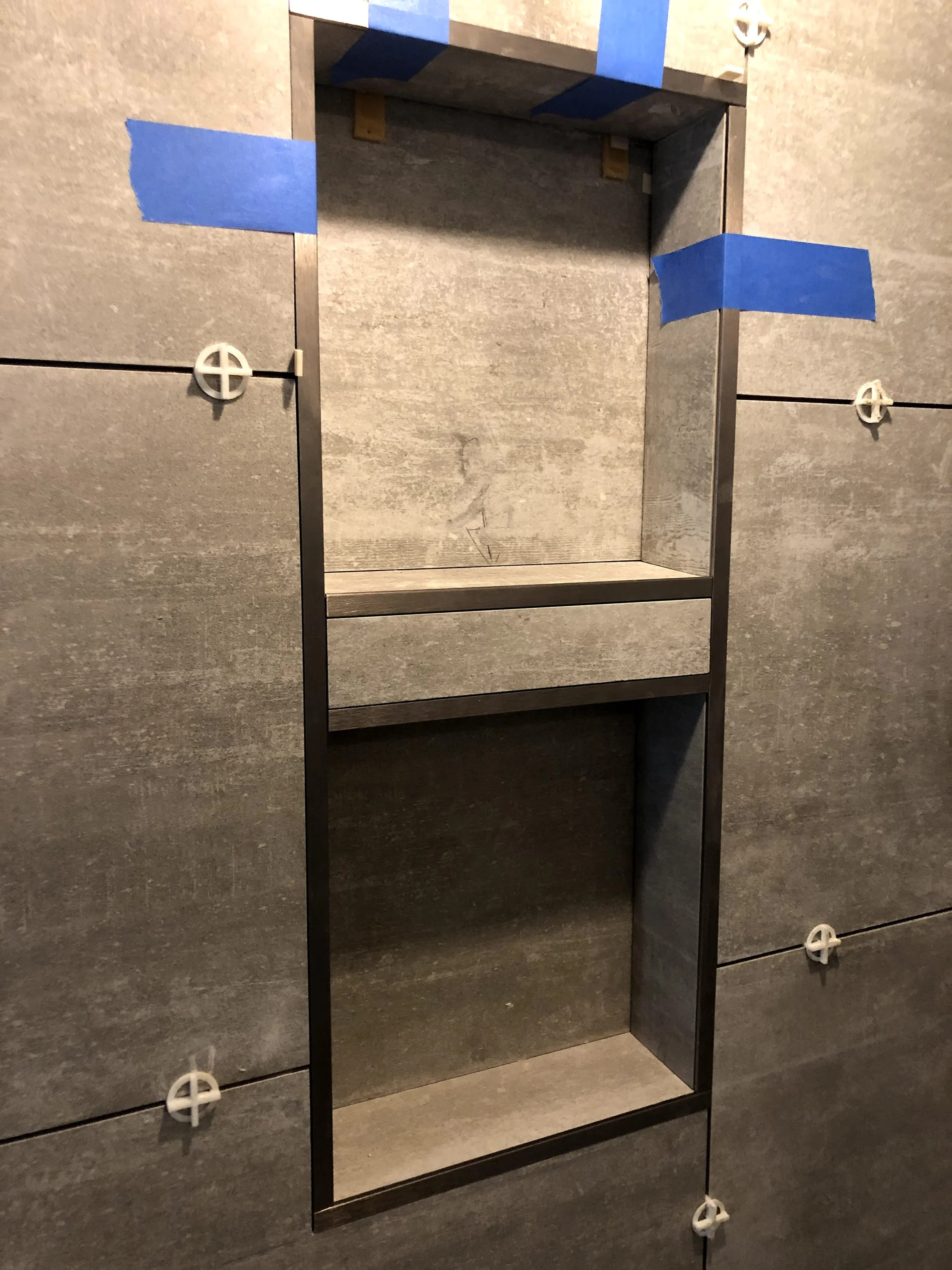Large format tile shower niche under construction.