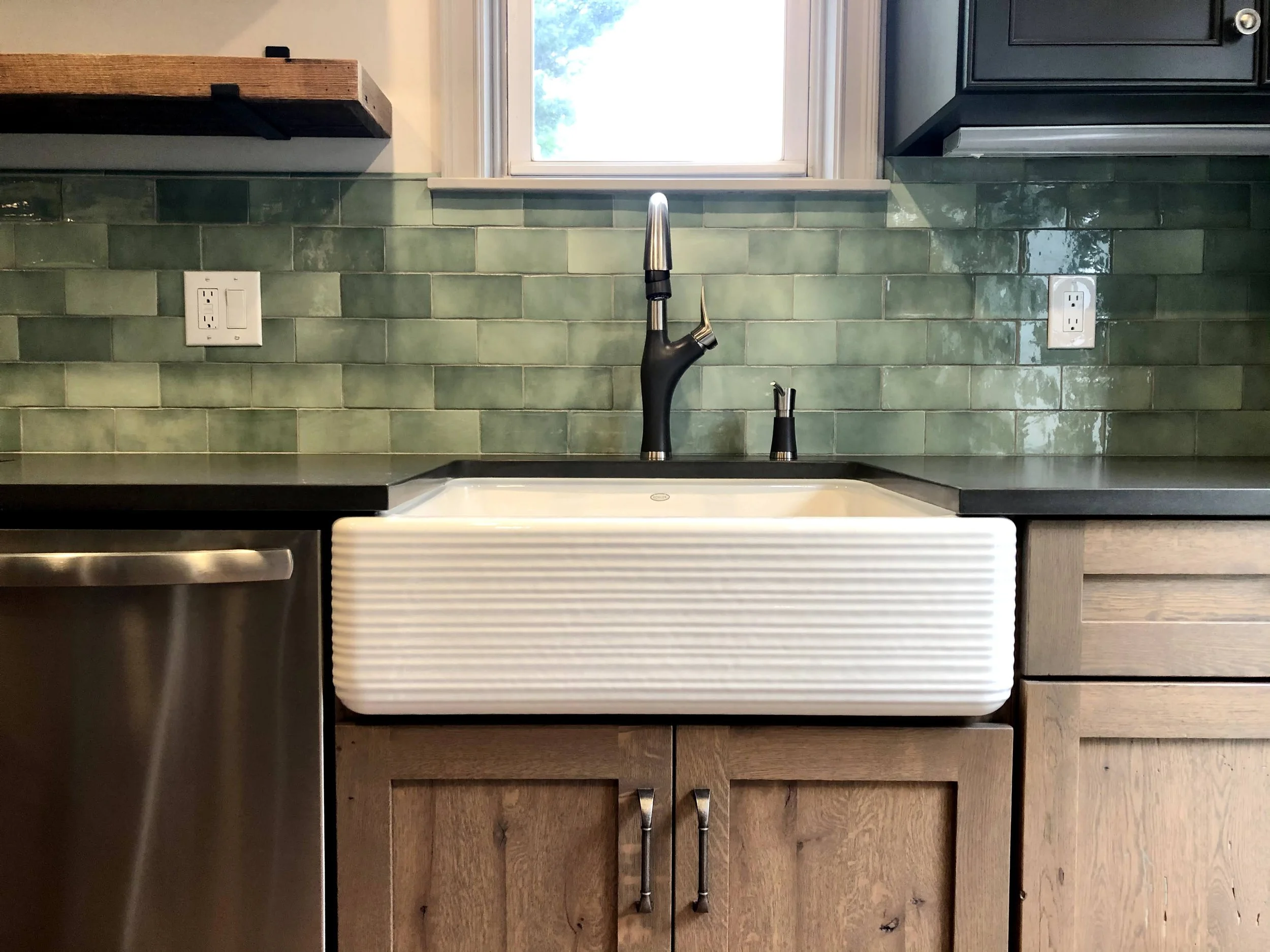 Farmhouse sink with green tiled backsplash in kitchen