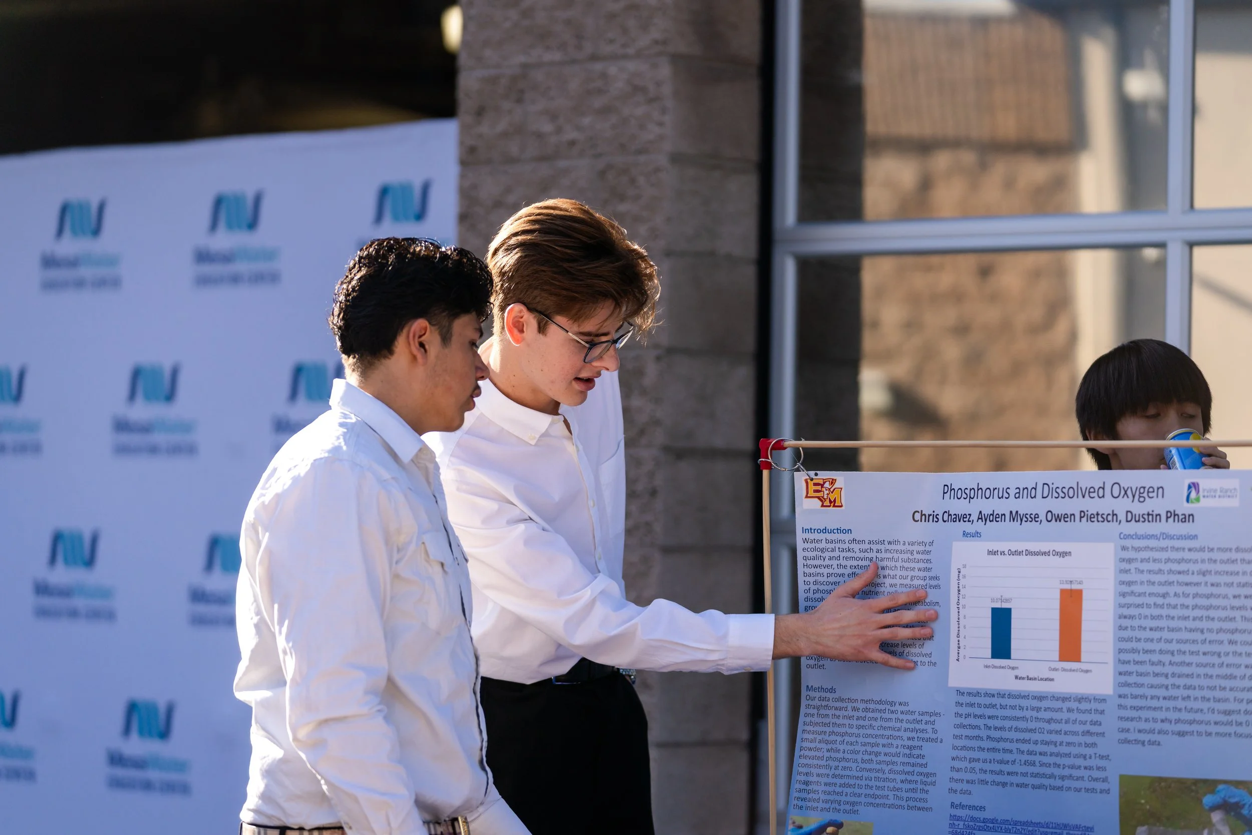 image shows student presenting their poster to another student 