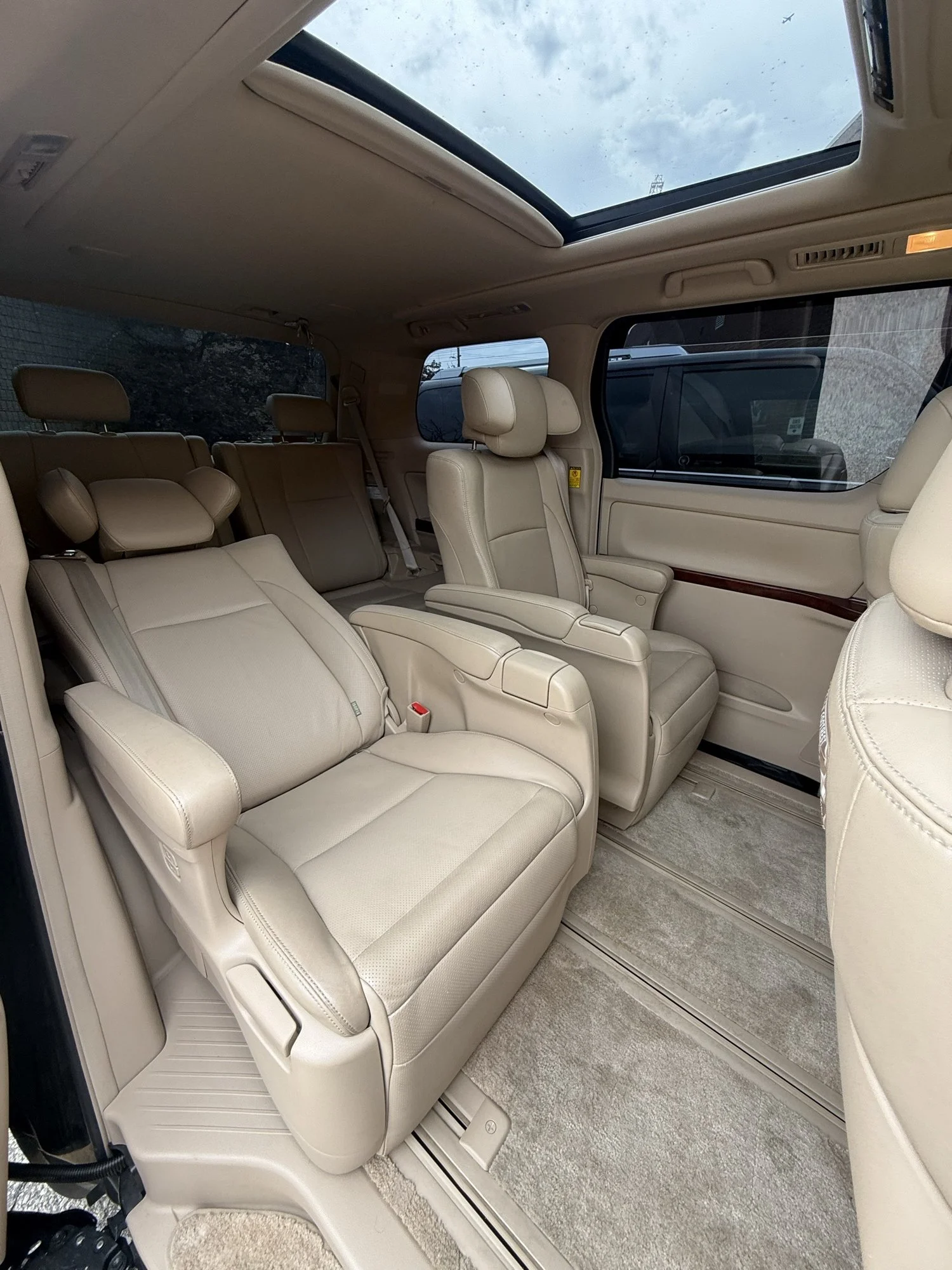 Cream leather cabin with captain seats and a panoramic glass roof