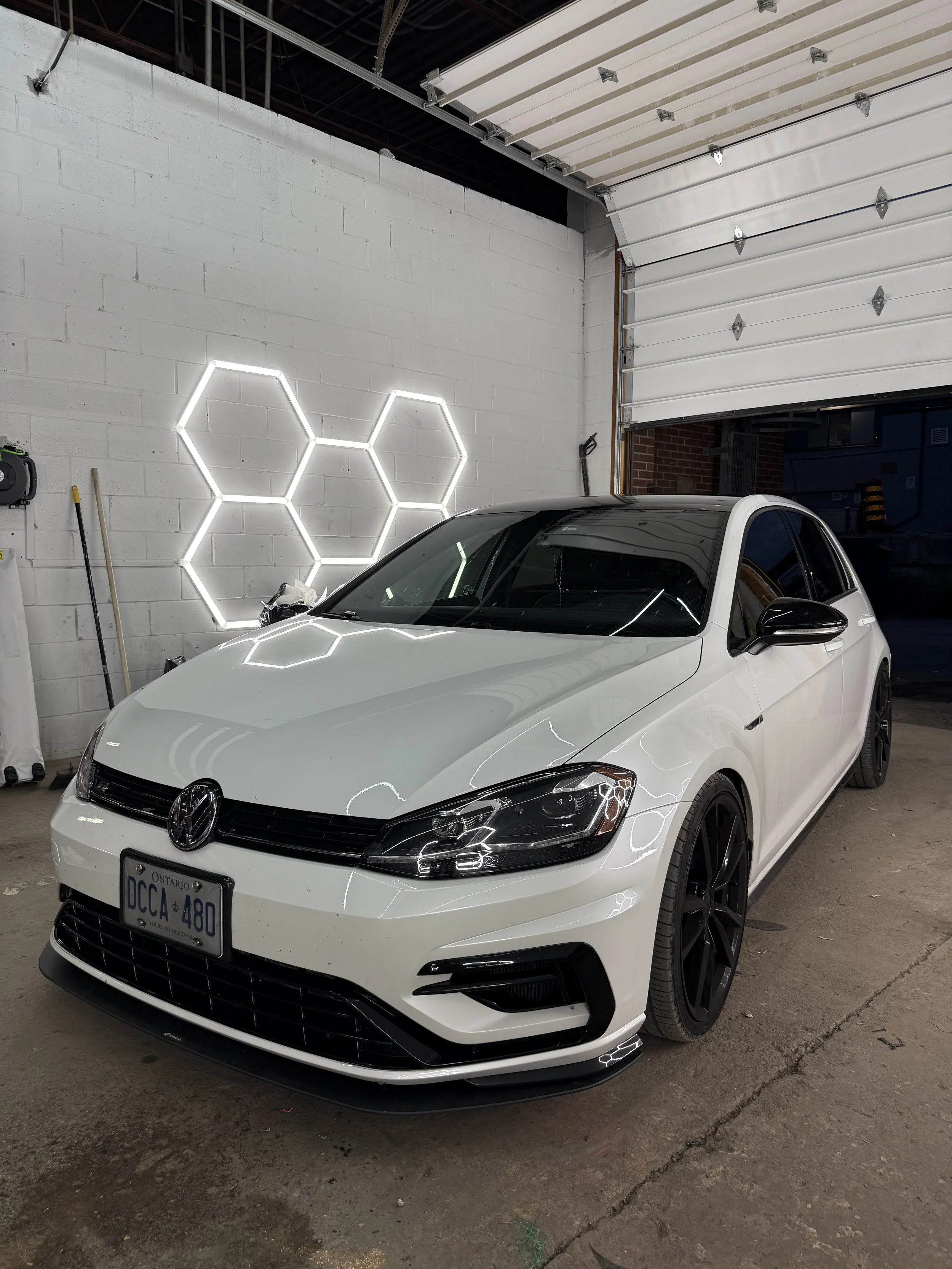 White Volkswagen Golf R after detailing under studio hex lights