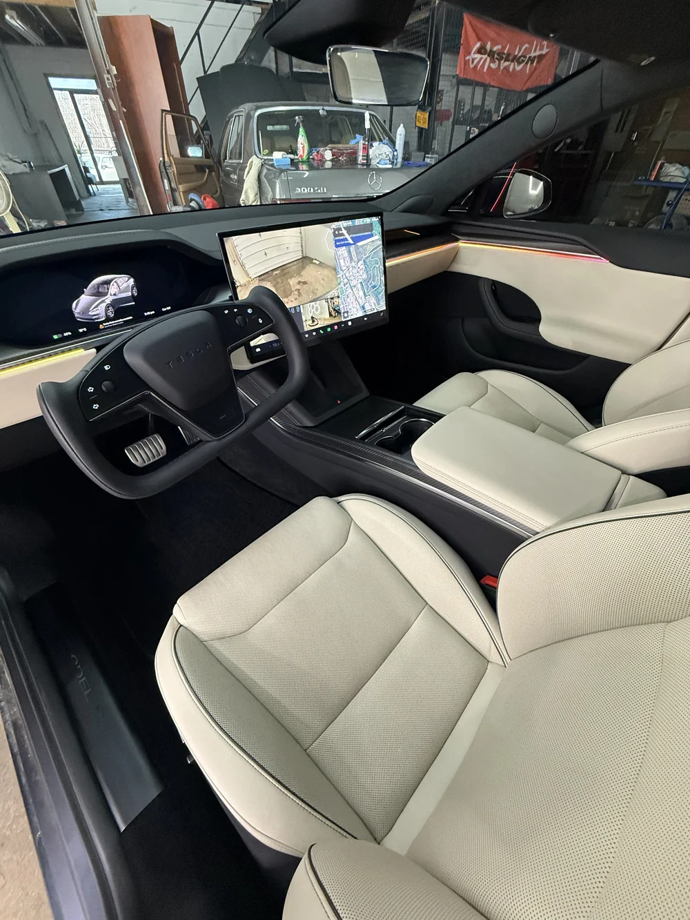 Detailed Tesla interior with cream leather seats and central touchscreen