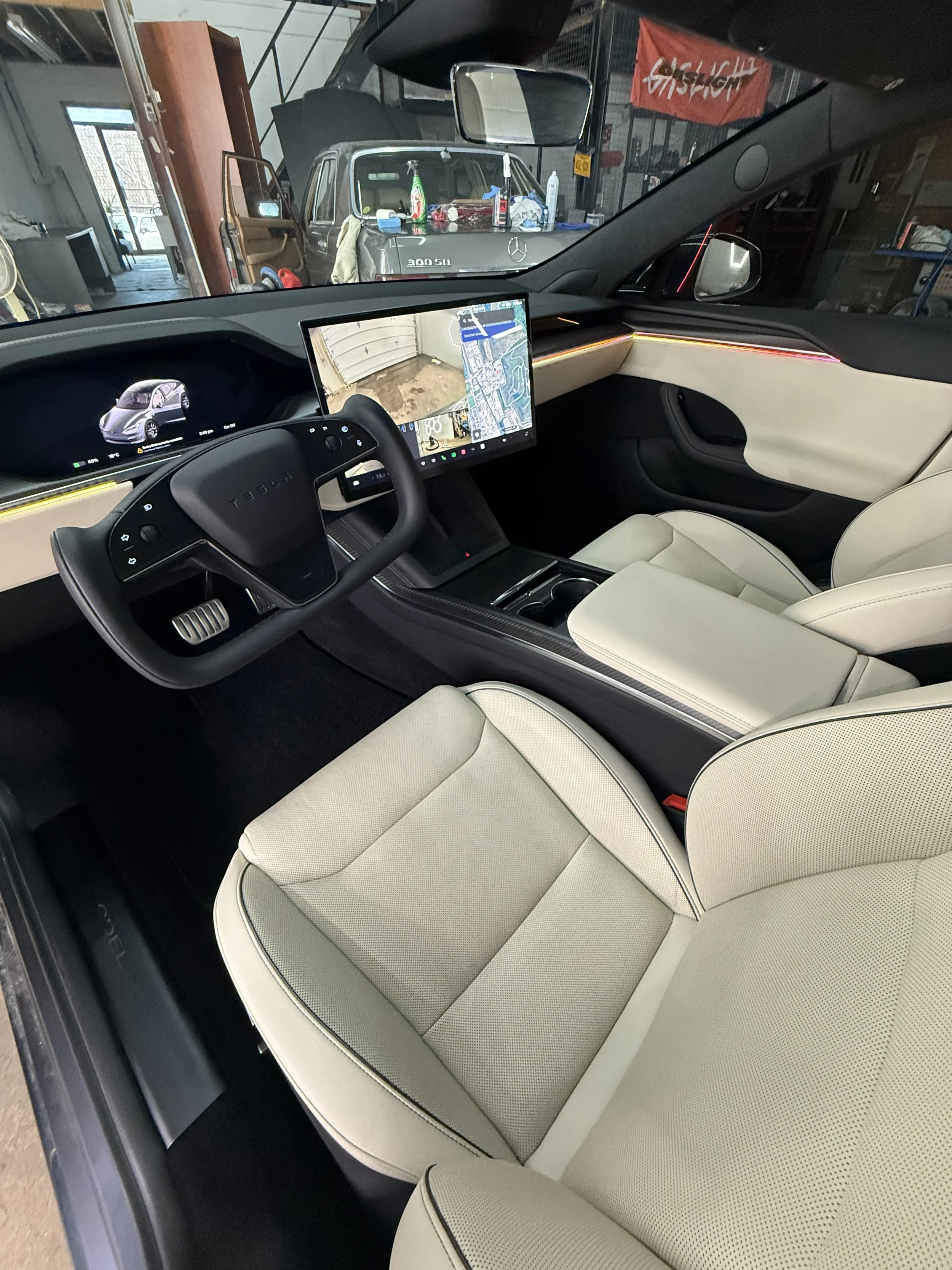 Clean Tesla cabin with cream seats and a central touchscreen at Ultraviolet Detailing Studio