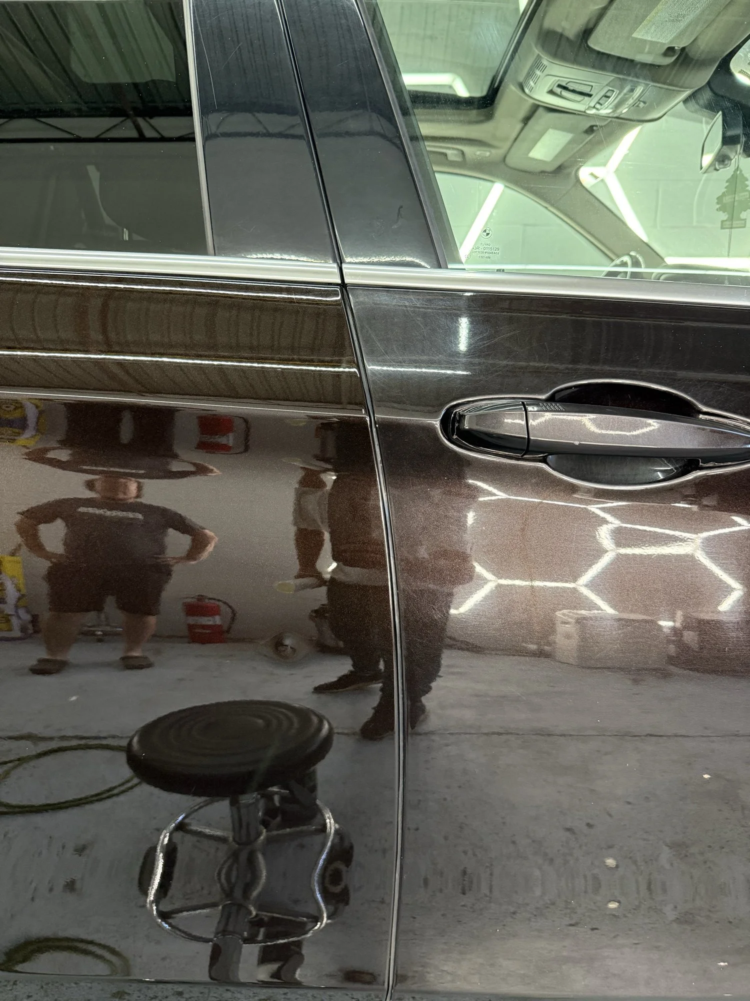 Close-up of BMW paint showing a clearer finish beside visible swirl marks