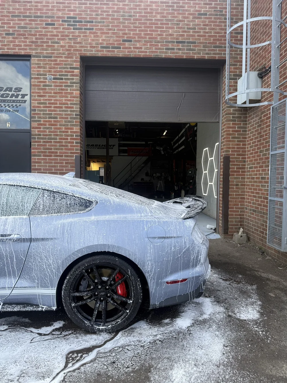 Ford Mustang rear quarter and wheel during a foam wash