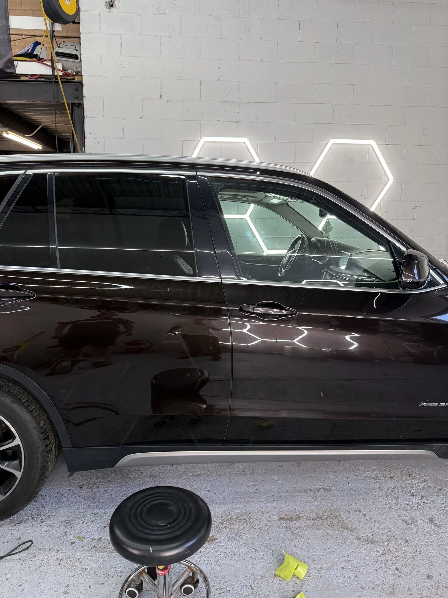 Dark BMW SUV side profile under the studio inspection lights