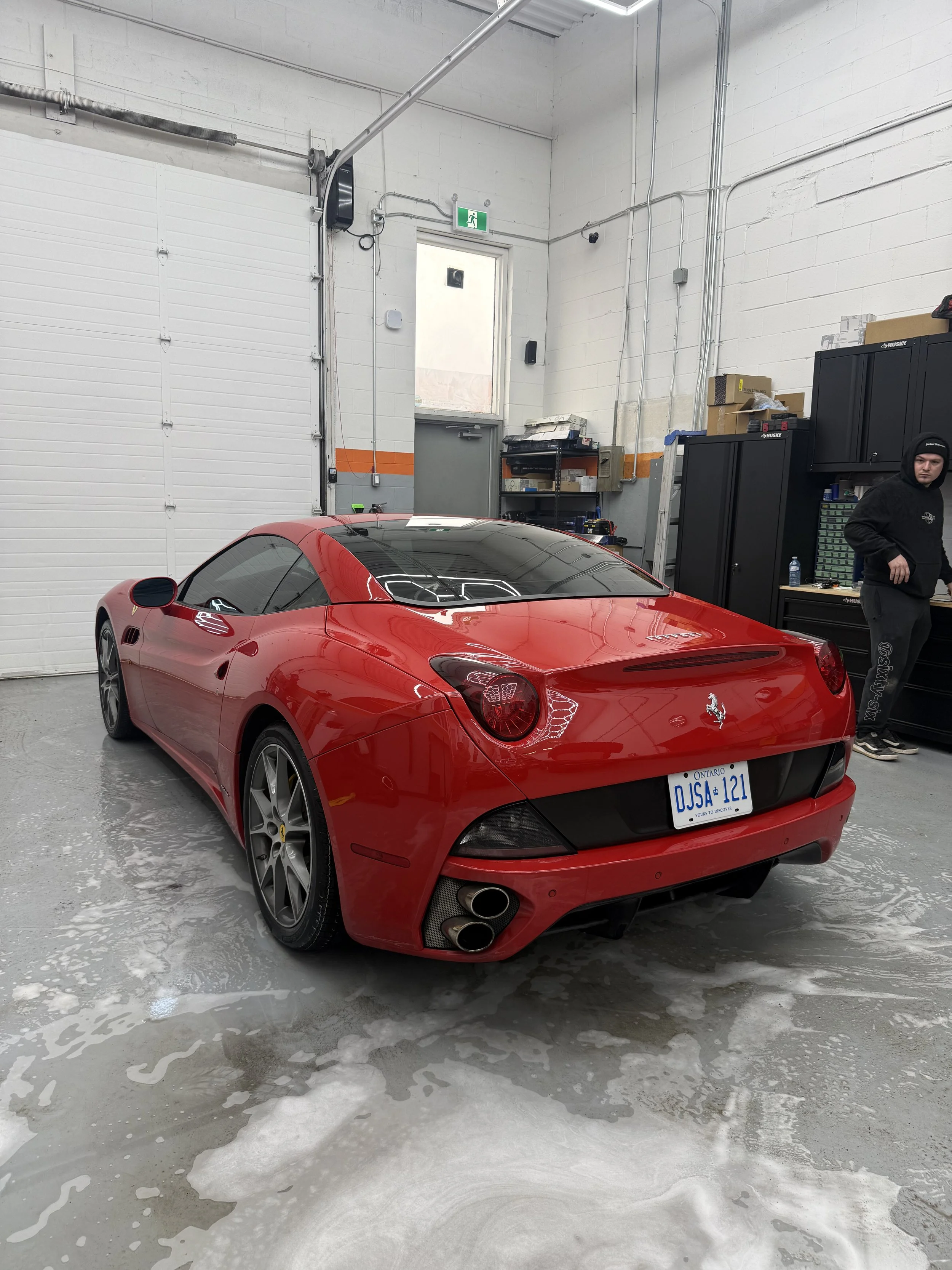 Red Ferrari California after a wash inside the detailing studio