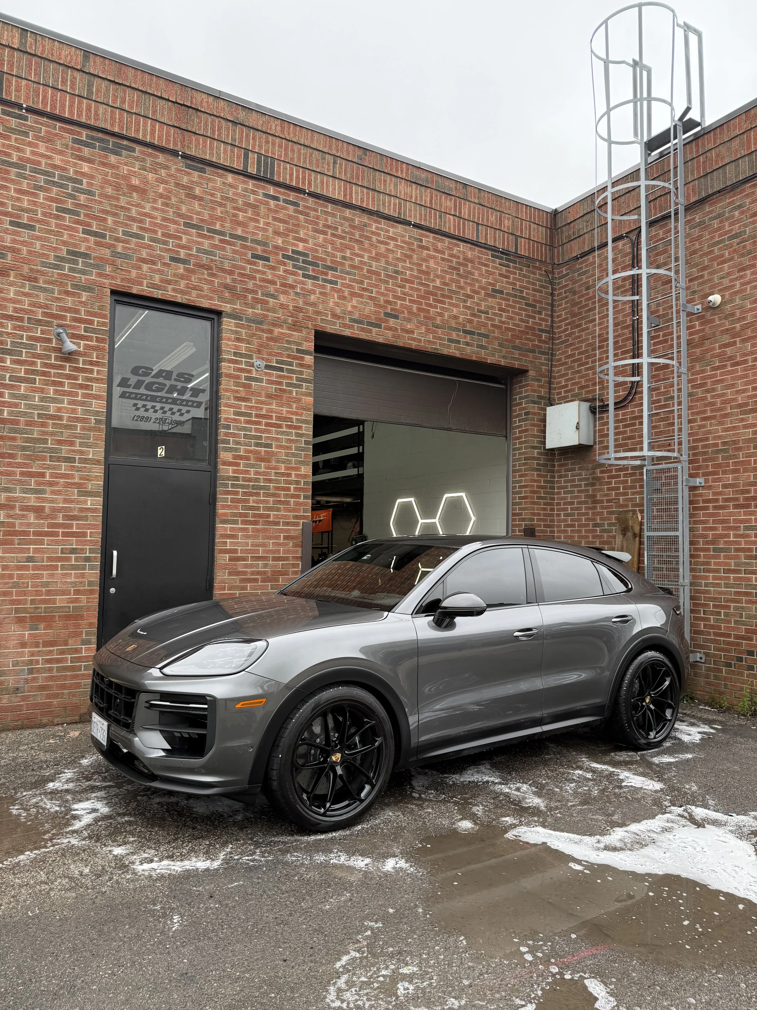 Gray Porsche Cayenne outside the Maple detailing studio