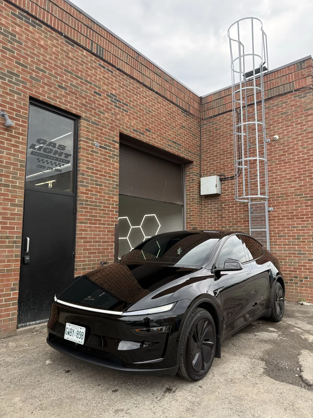 Black Tesla Model Y outside the Ultraviolet studio