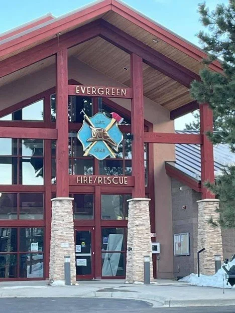 The entrance of a fire rescue station with a sign that says 'Evergreen Fire Rescue' and a firefighter emblem above the door.