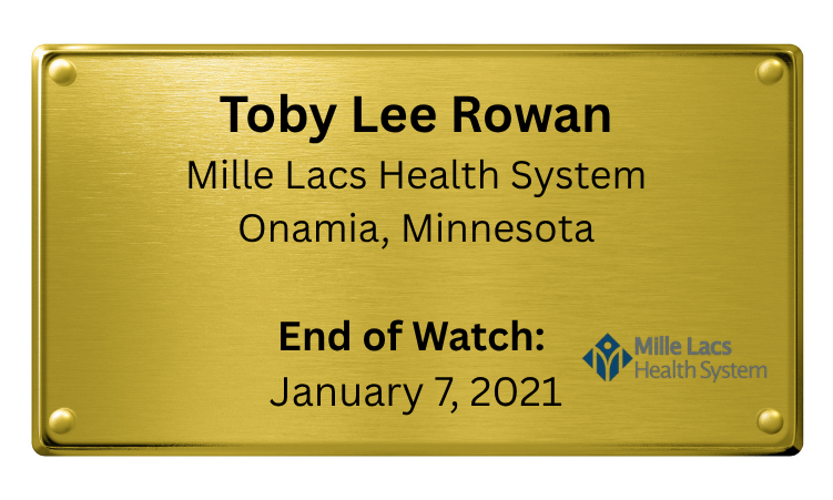 Gold-colored plaque with black and blue text, displaying the name Toby Lee Rowan, associated with Mille Lacs Health System in Onamia, Minnesota, and marking the 'End of Watch' date as January 7, 2021.