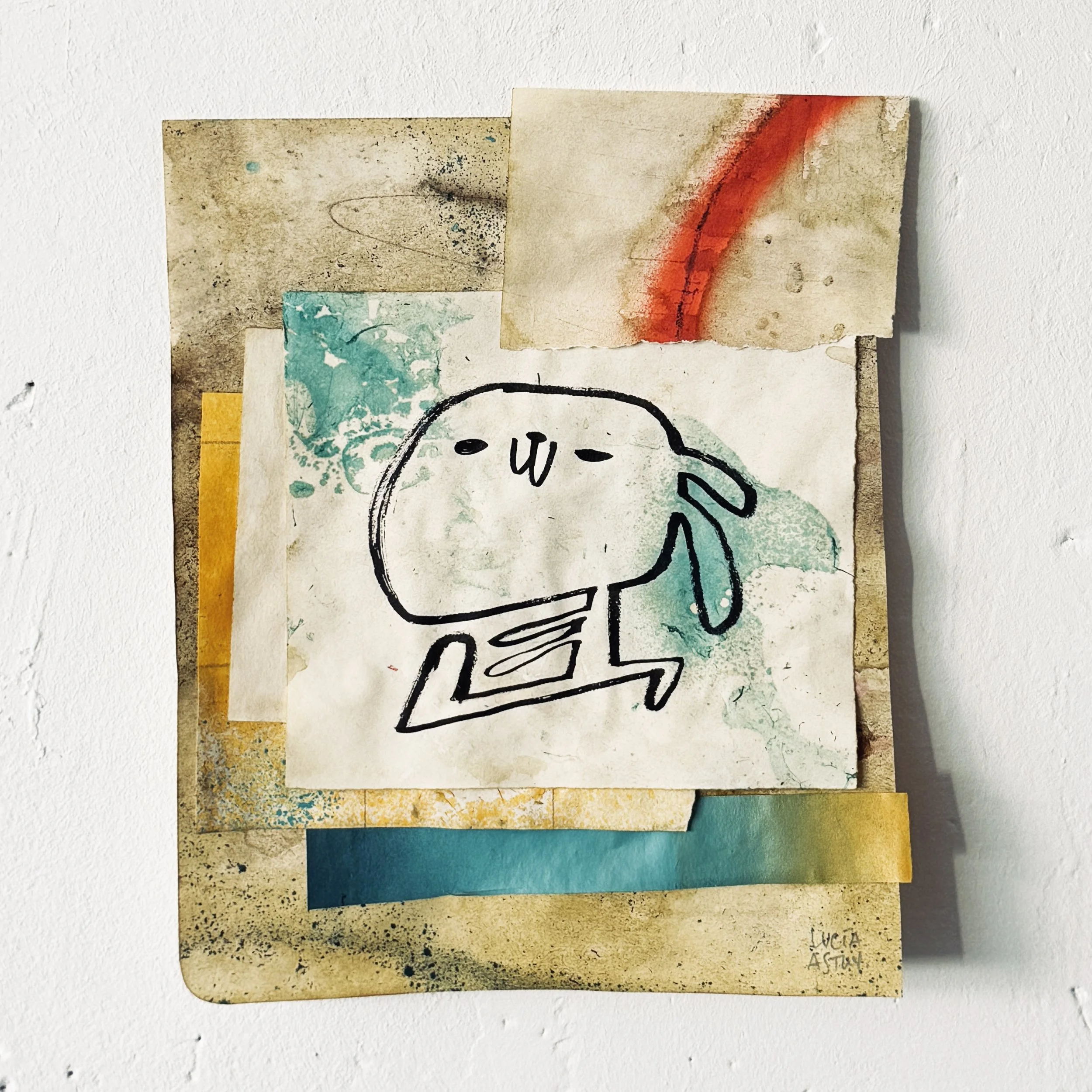 Recortes de papel con manchas, ilustraciones y textos escritos a mano en diferentes colores, pegados sobre una pared blanca, formando un collage colorido y artístico  por Lucía Astuy.