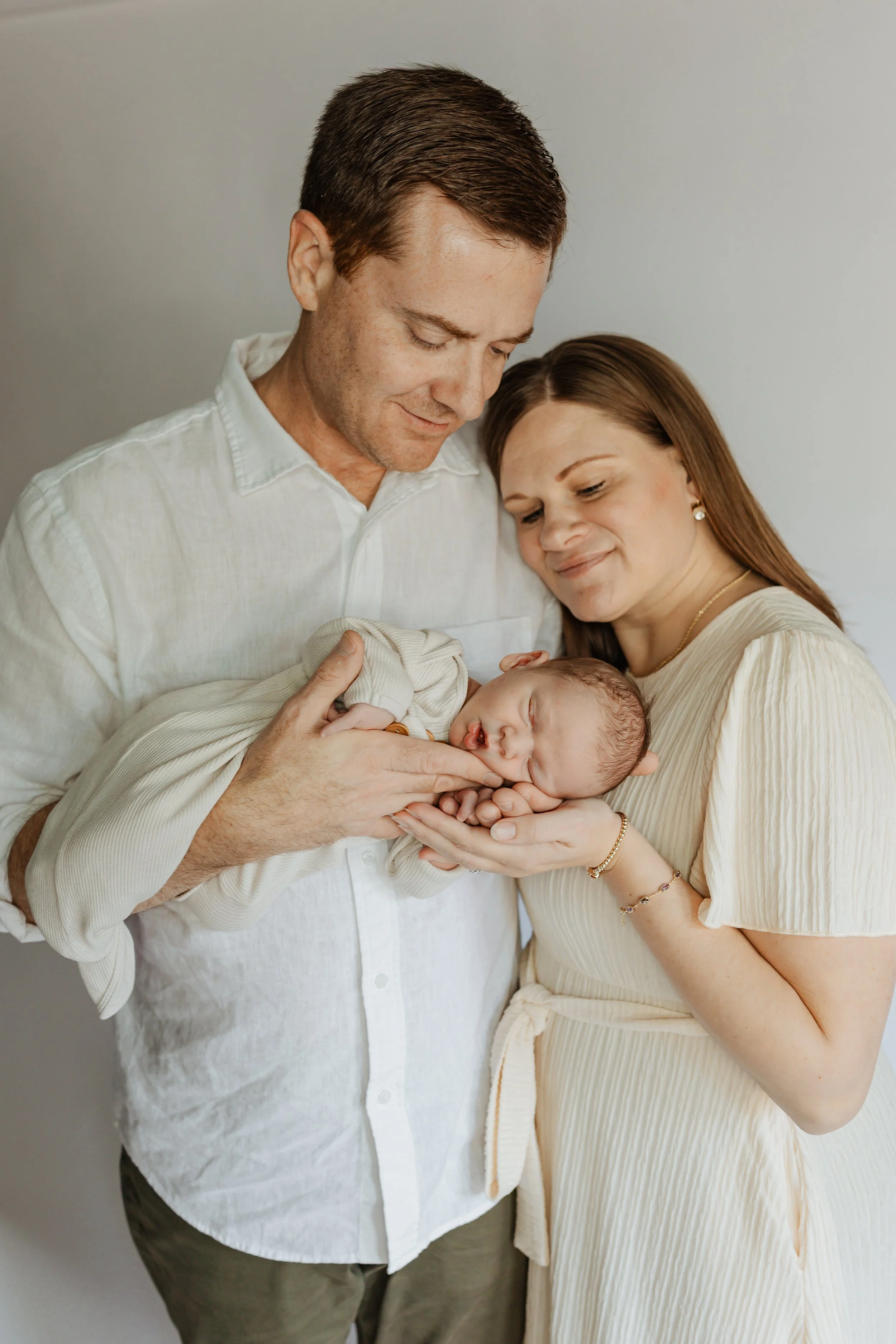 Mike Falco and his wife are holding their sleeping newborn son