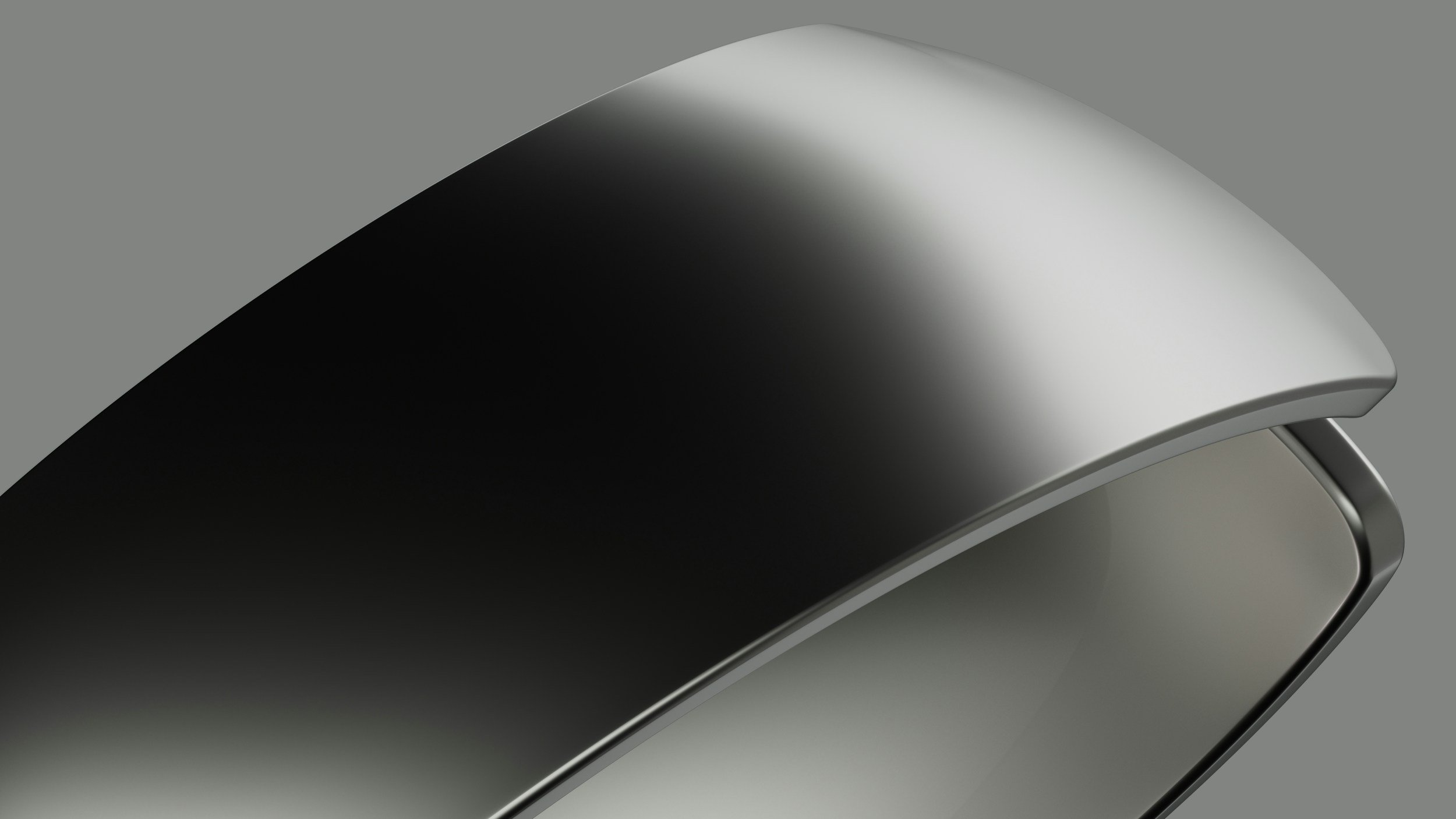 Close-up of a sleek, modern, metallic device, possibly a smartwatch or fitness tracker, against a gray background.