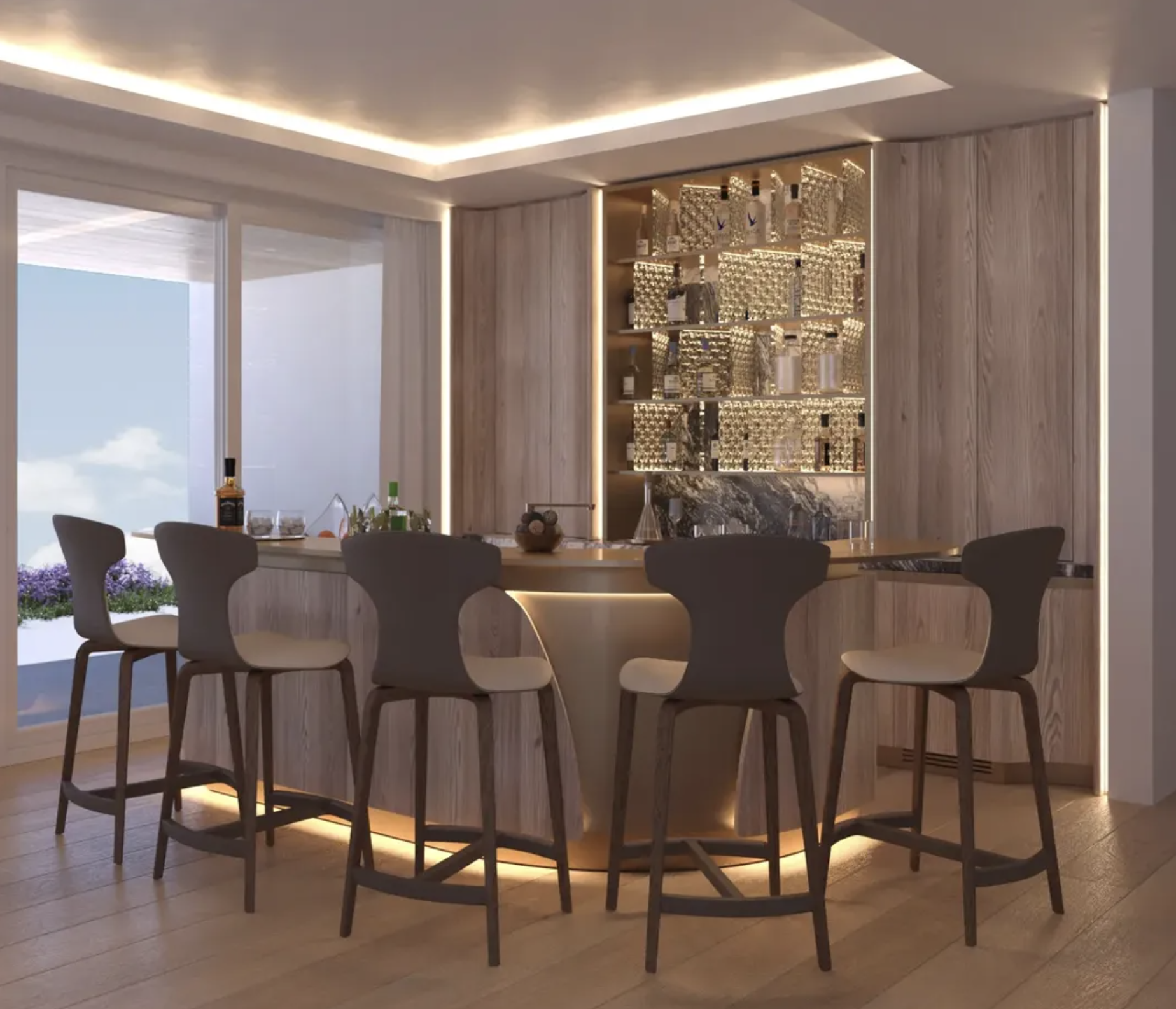 Modern dining area with a circular wooden table and six matching chairs. Behind the table is a bar area with shelves holding bottles and glasses, illuminated with soft LED lighting. Large window with a view of a blue sky and flowers outside.
