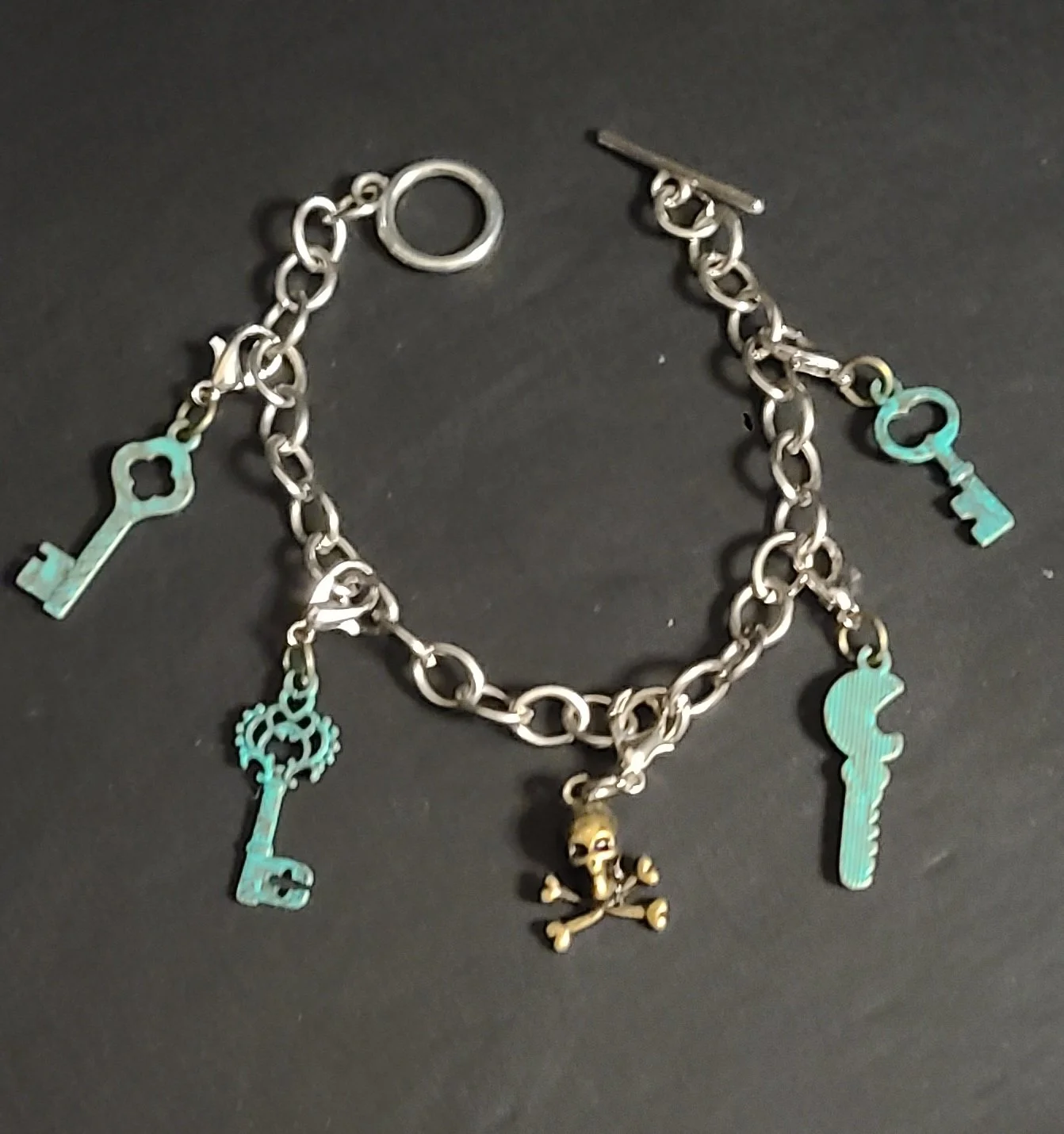 Up-close picture of an Assembled Artifacts silver bracelet with charms.