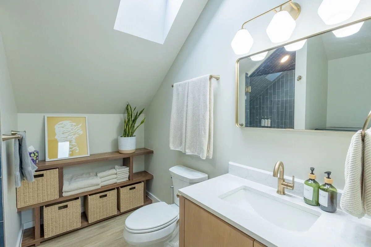 Fully stocked bathroom with fresh towels, hair dryer, and toiletries under a skylight in our Denver rental
