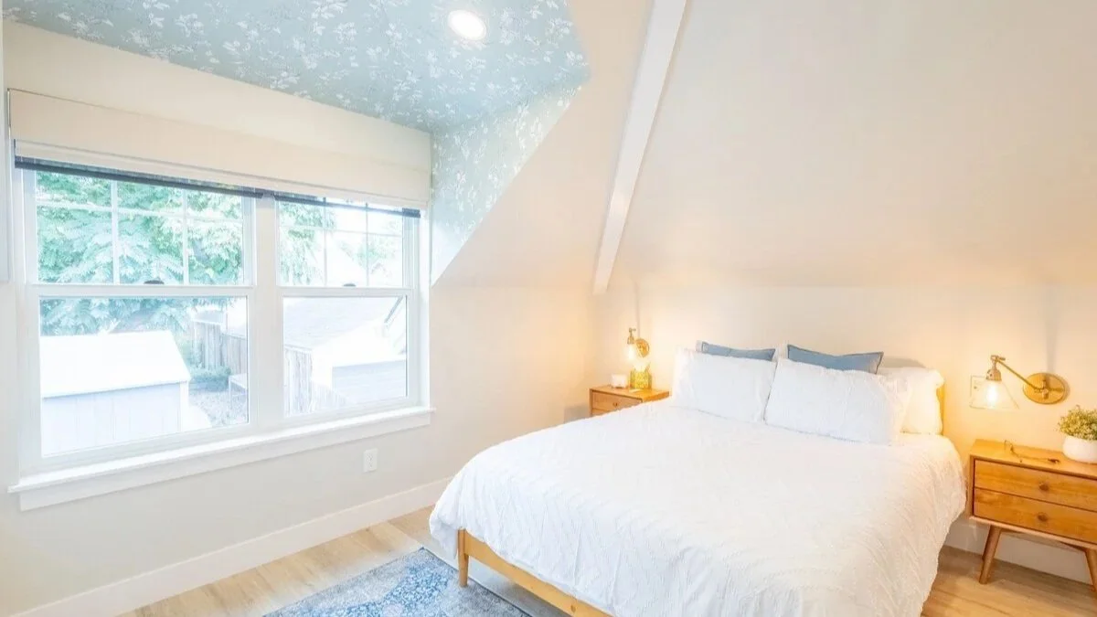 Queen bedroom with vaulted ceiling and bedside sconces — one of two serene bedrooms in our Denver carriage house