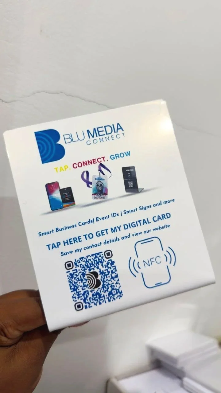 Smart sign advertising Blu Media Connect showcasing smart business cards, event IDs, smart signs, and more. It features a QR code and NFC symbol, encouraging viewers to tap to get a digital card and view a website.