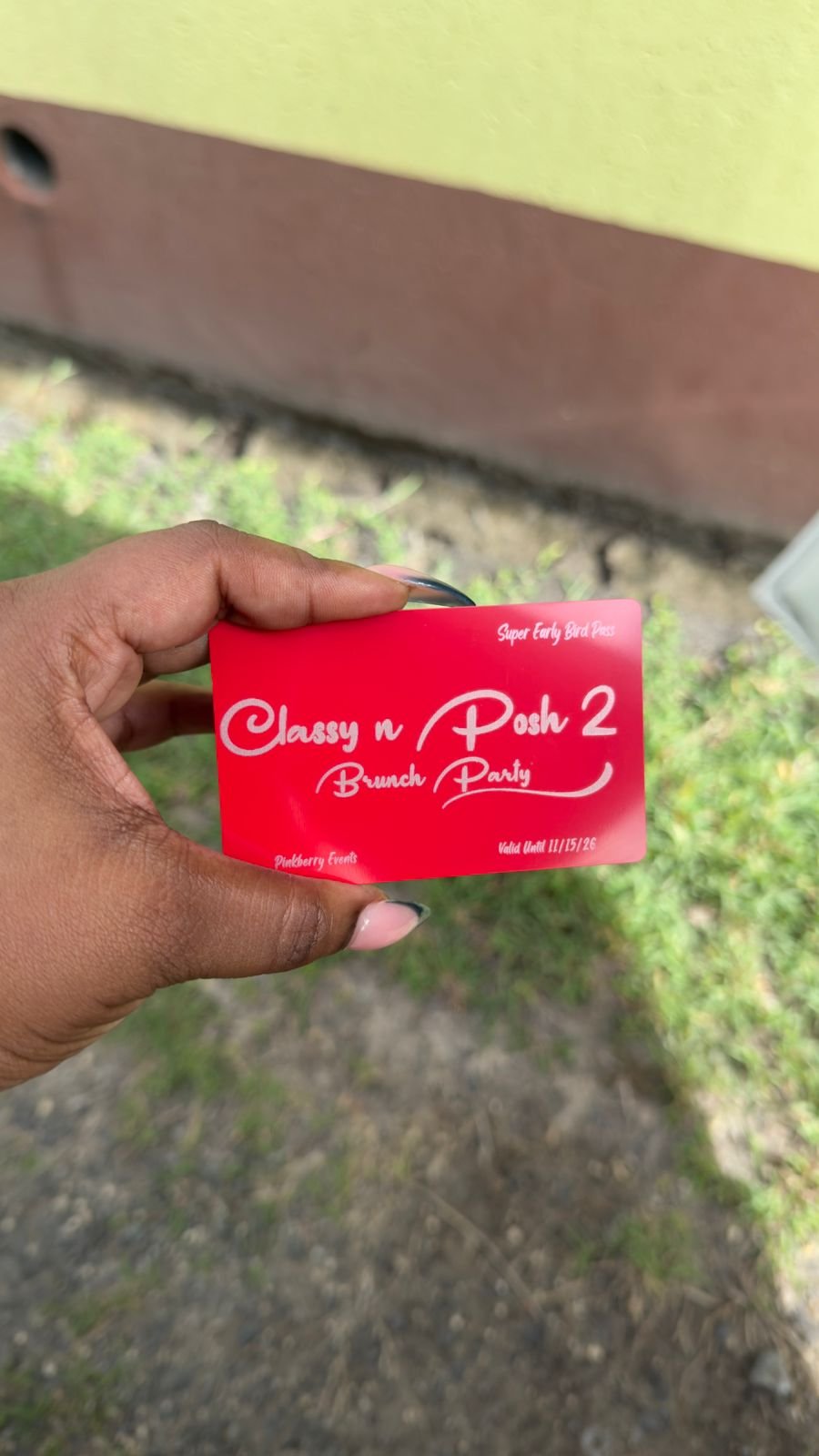 A person's hand holding a red ticket for a brunch party event called 'Classy n Posh 2' organized by Pinkberry Events, valid until November 15, 2026.