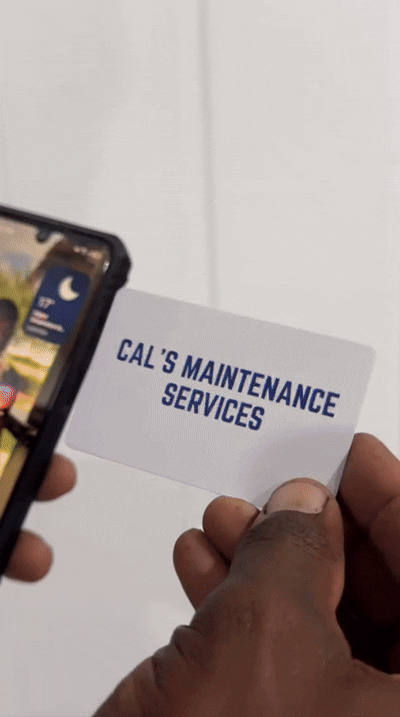 Hand holding business card that reads 'Cal's Maintenance Services' with a person tapping it.