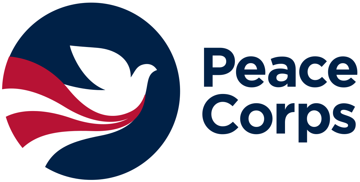 Logo of Peace Corps features a white dove inside a dark blue circle, with red and black wavy stripes flowing from the dove, and the words 'Peace Corps' written in dark blue next to it.