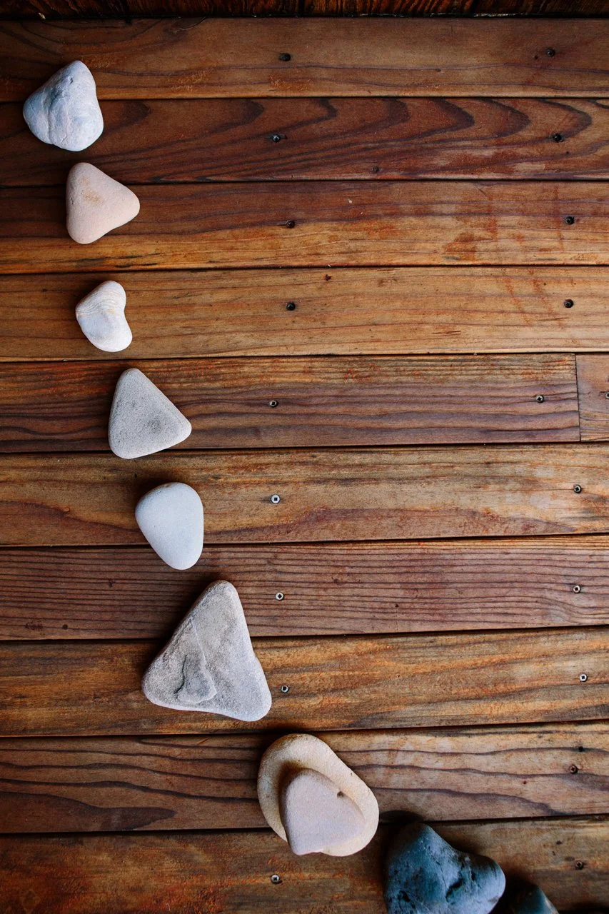 Line of white and gray rocks of various sizes on a wooden floor in Malibu