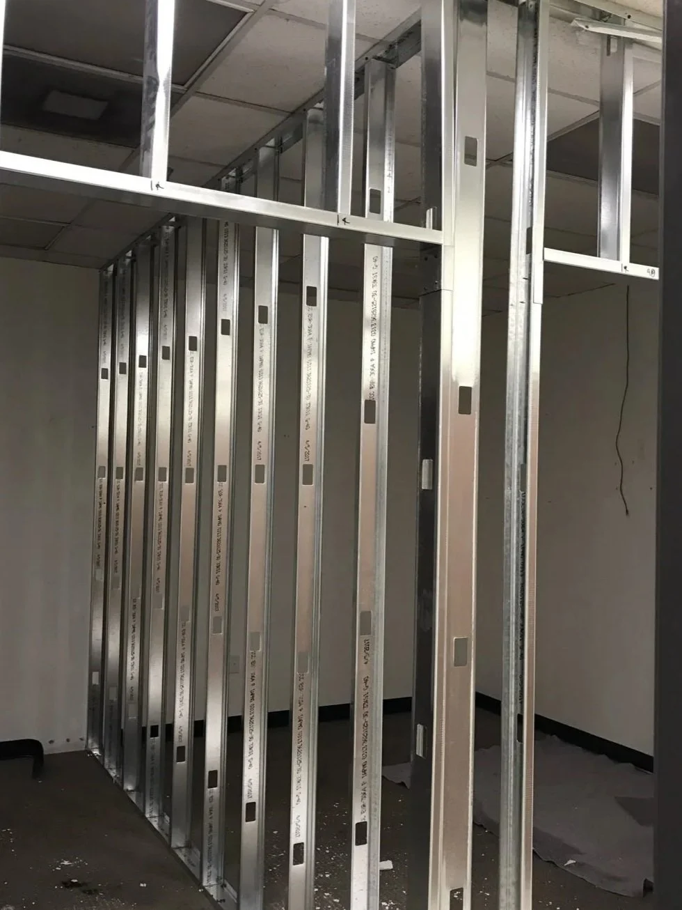 Estructura metálica en construcción en una habitación vacía.
