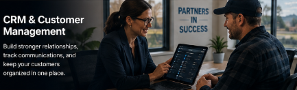 Two people in a meeting room, working on a CRM and customer management presentation, with a laptop and a plant in the background.